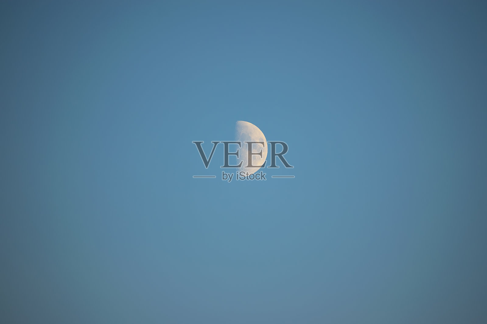 月亮在傍晚蓝天的背景下。第一季度的阶段。照片摄影图片