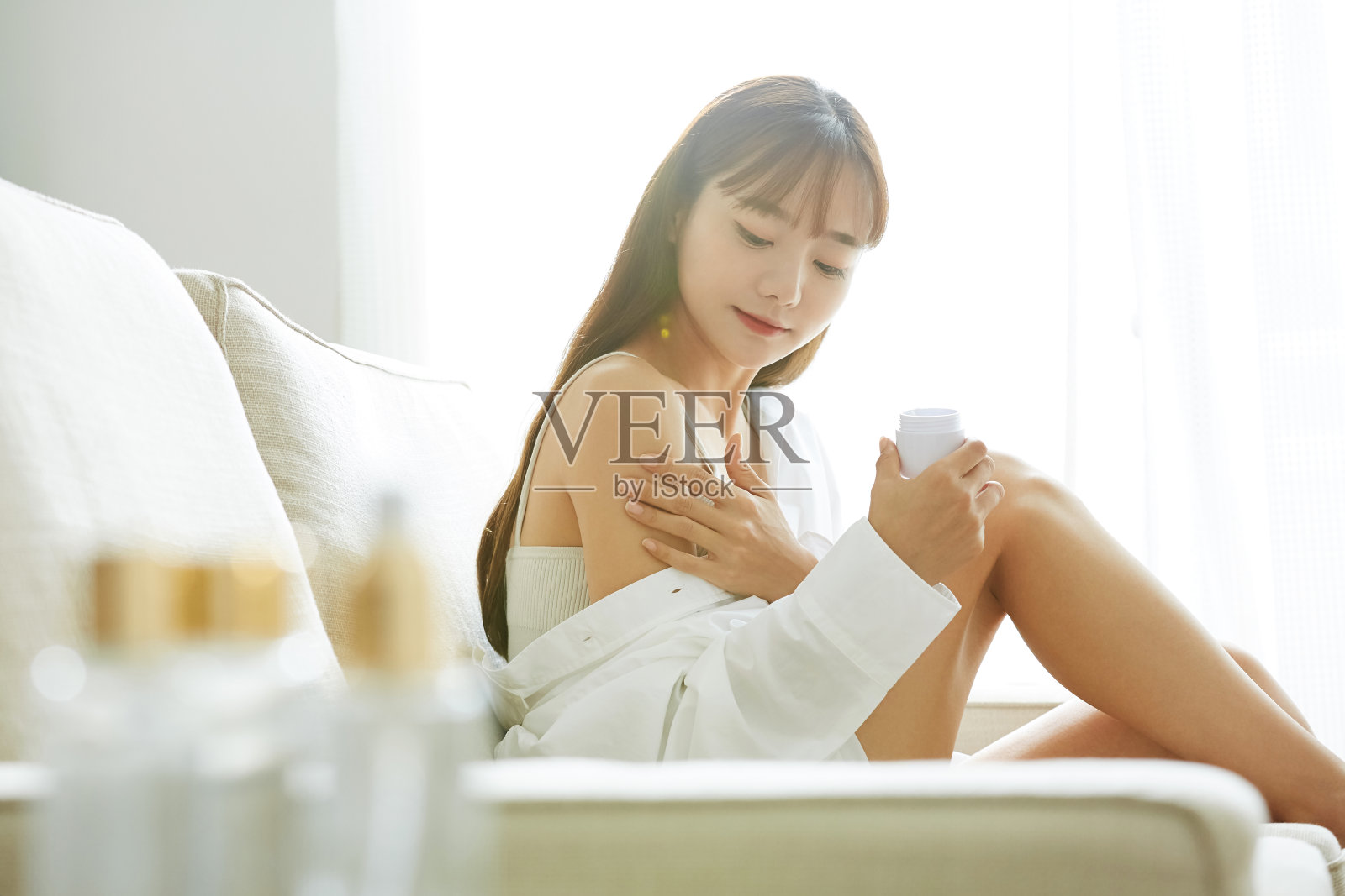 年轻的亚洲女人在沙发上做皮肤护理照片摄影图片