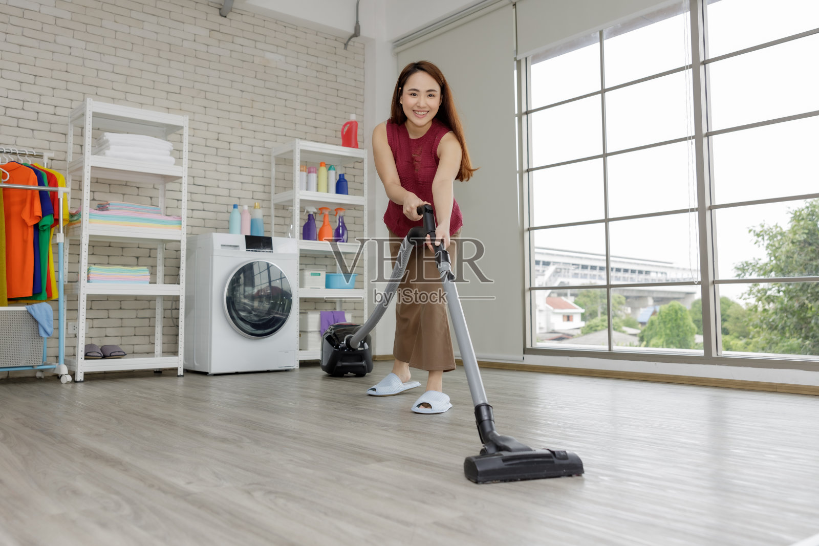 年轻的亚洲女性家庭主妇在房间公寓吸尘照片摄影图片