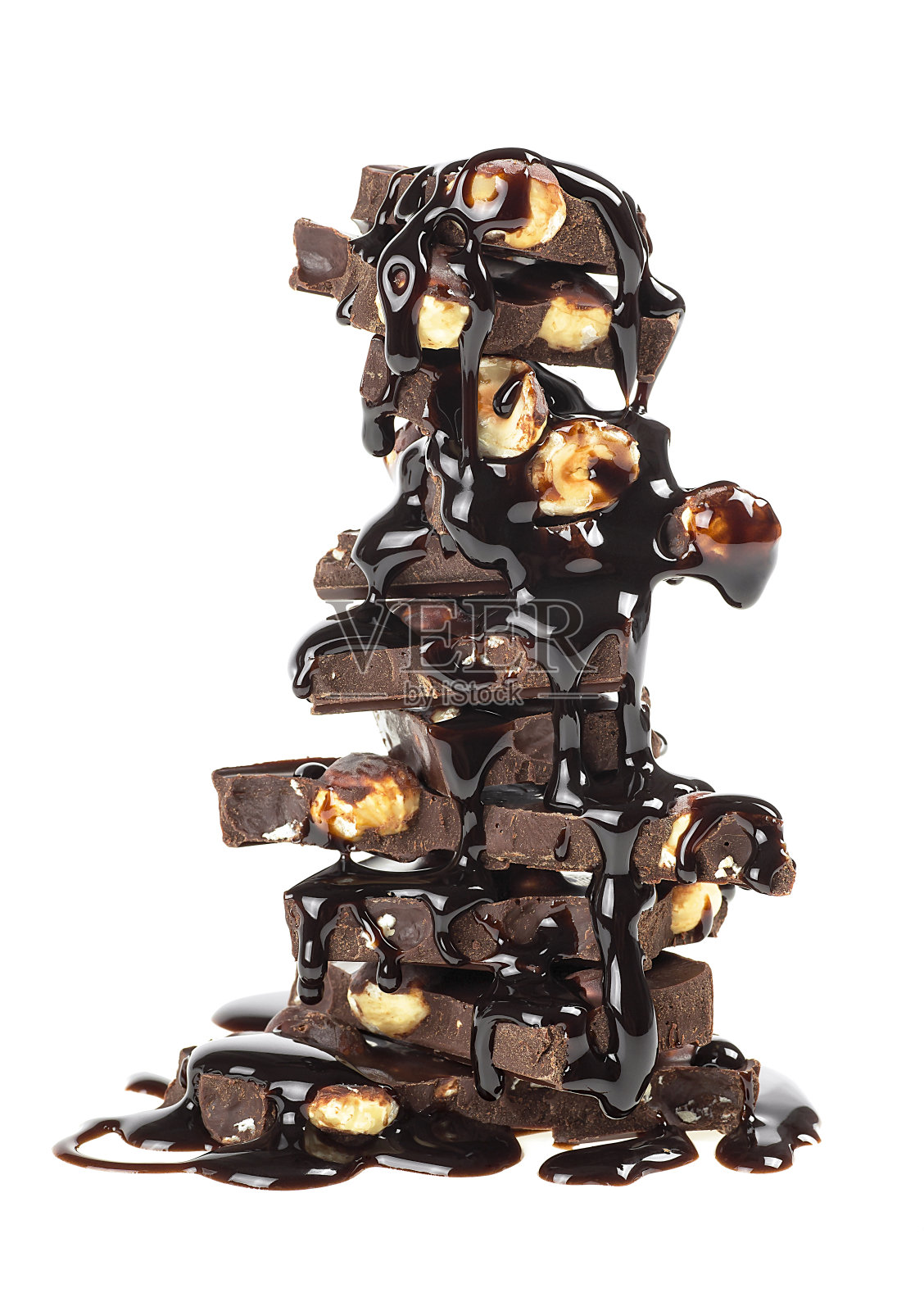 在白色的背景上，一堆巧克力和坚果。融化的巧克力块。照片摄影图片
