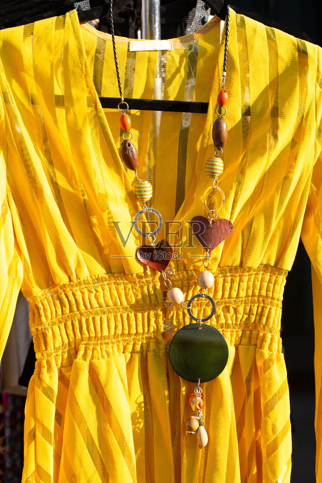 当地露天集市上出售的亮黄色连衣裙照片摄影图片