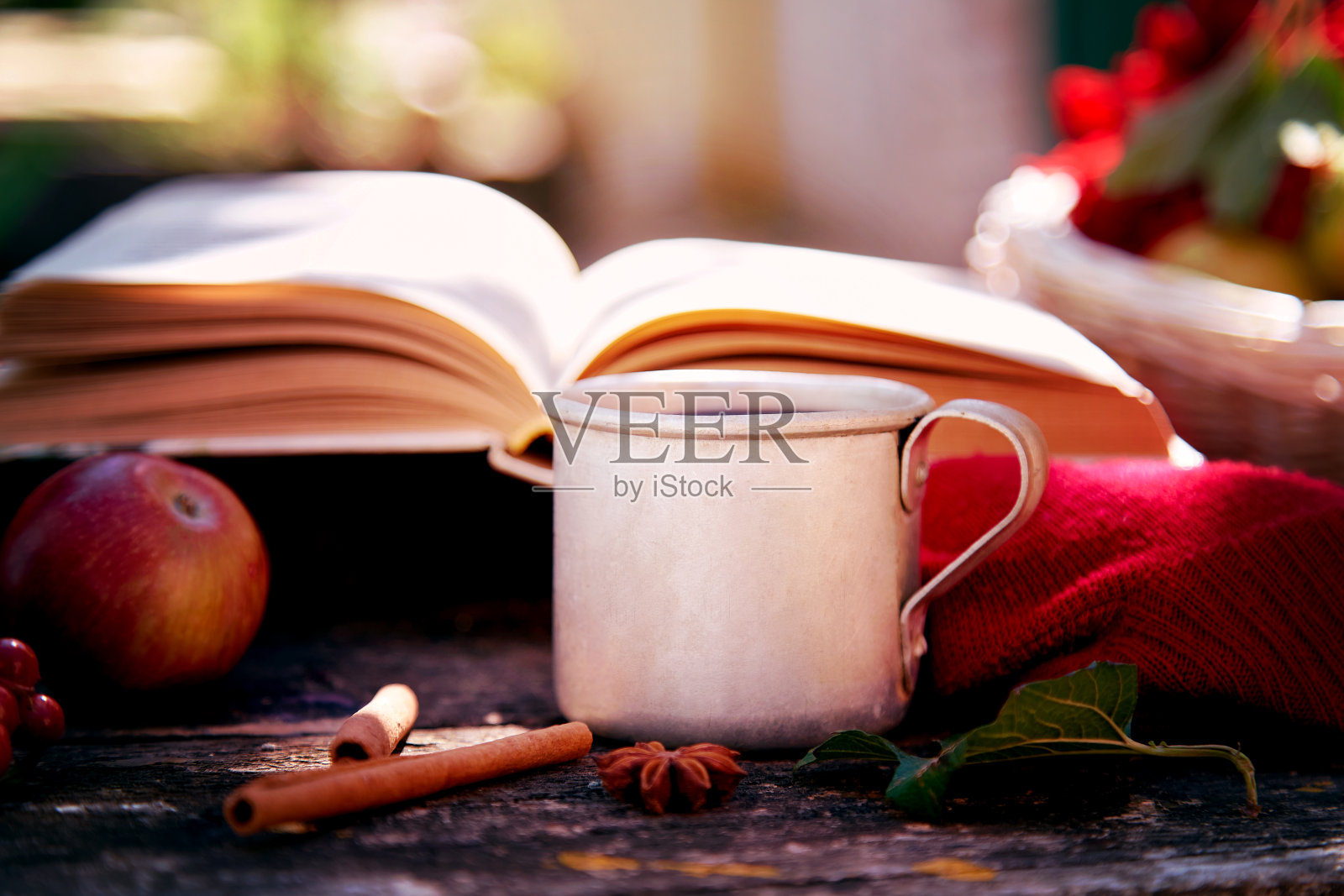 舒适的秋天概念与一杯茶，古董书，苹果在乡村风格。秋天美学静物伴影，大丽花红。温馨的家，温暖的围巾和茶。感恩节的概念照片摄影图片