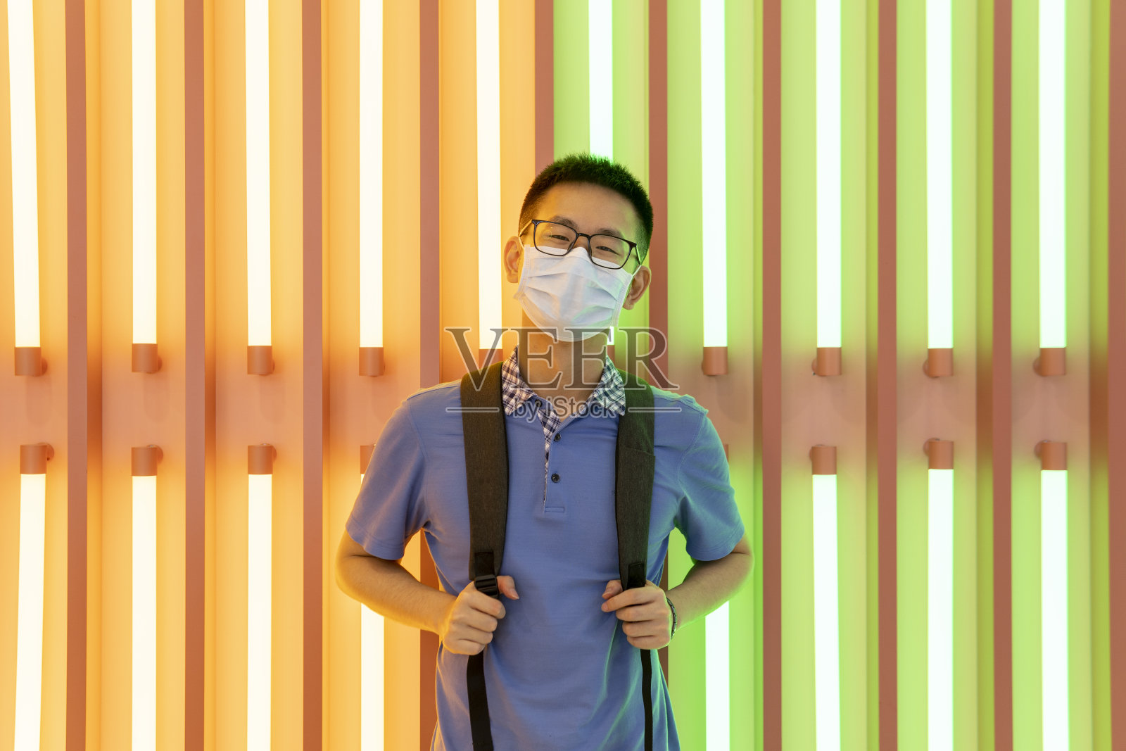 亚洲男子在霓虹灯前的面具后微笑照片摄影图片