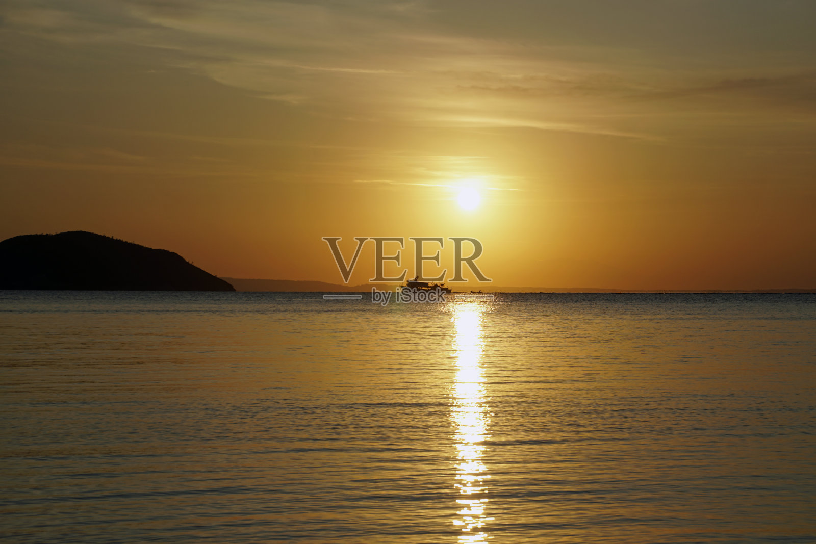 爱琴海上鲜红的夕阳。太阳和山脉。船的轮廓和轮廓。海浪和眩光。照片摄影图片