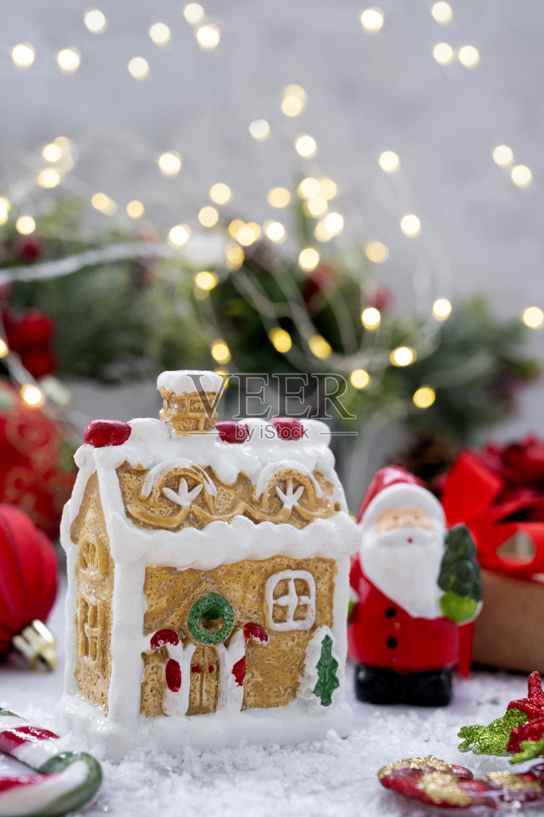 姜饼屋与圣诞装饰，红色小玩意，冷杉树枝，礼品盒和散景灯。照片摄影图片