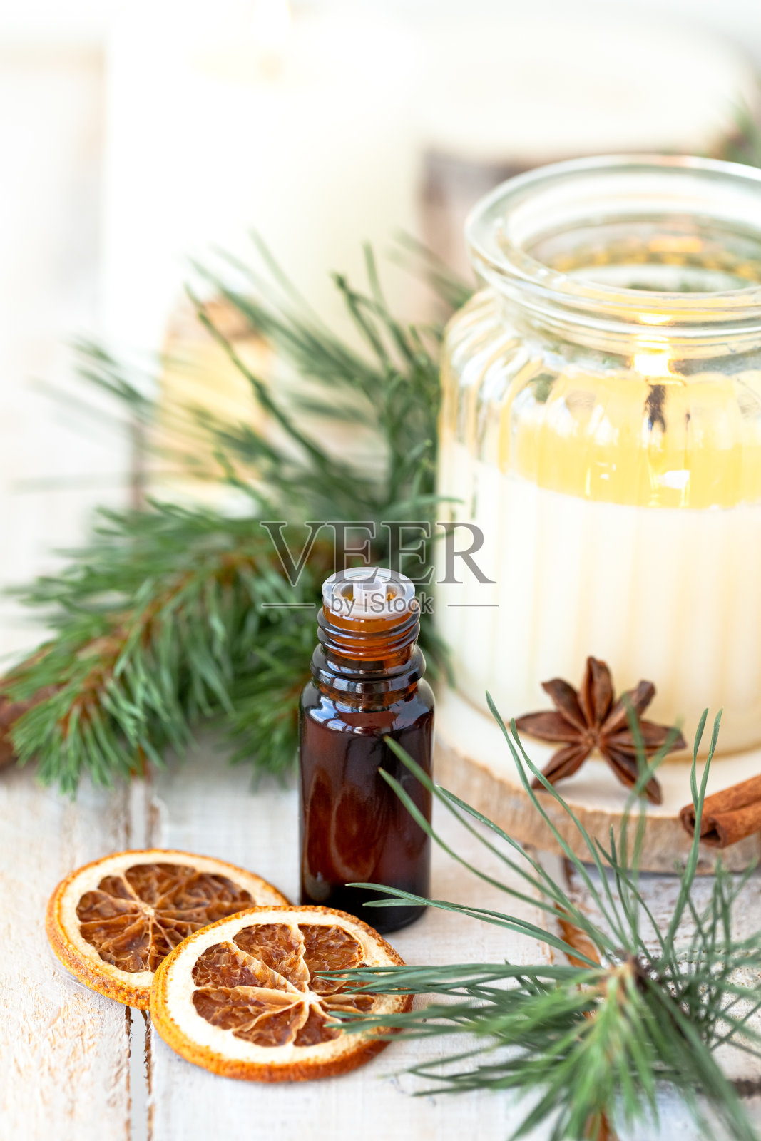 各种各样的天然圣诞精油在小瓶。蜡烛，冷杉树枝。香薰，温馨的居家氛围，节日喜庆的心情。特写宏观，木制背景。“零浪费”照片摄影图片