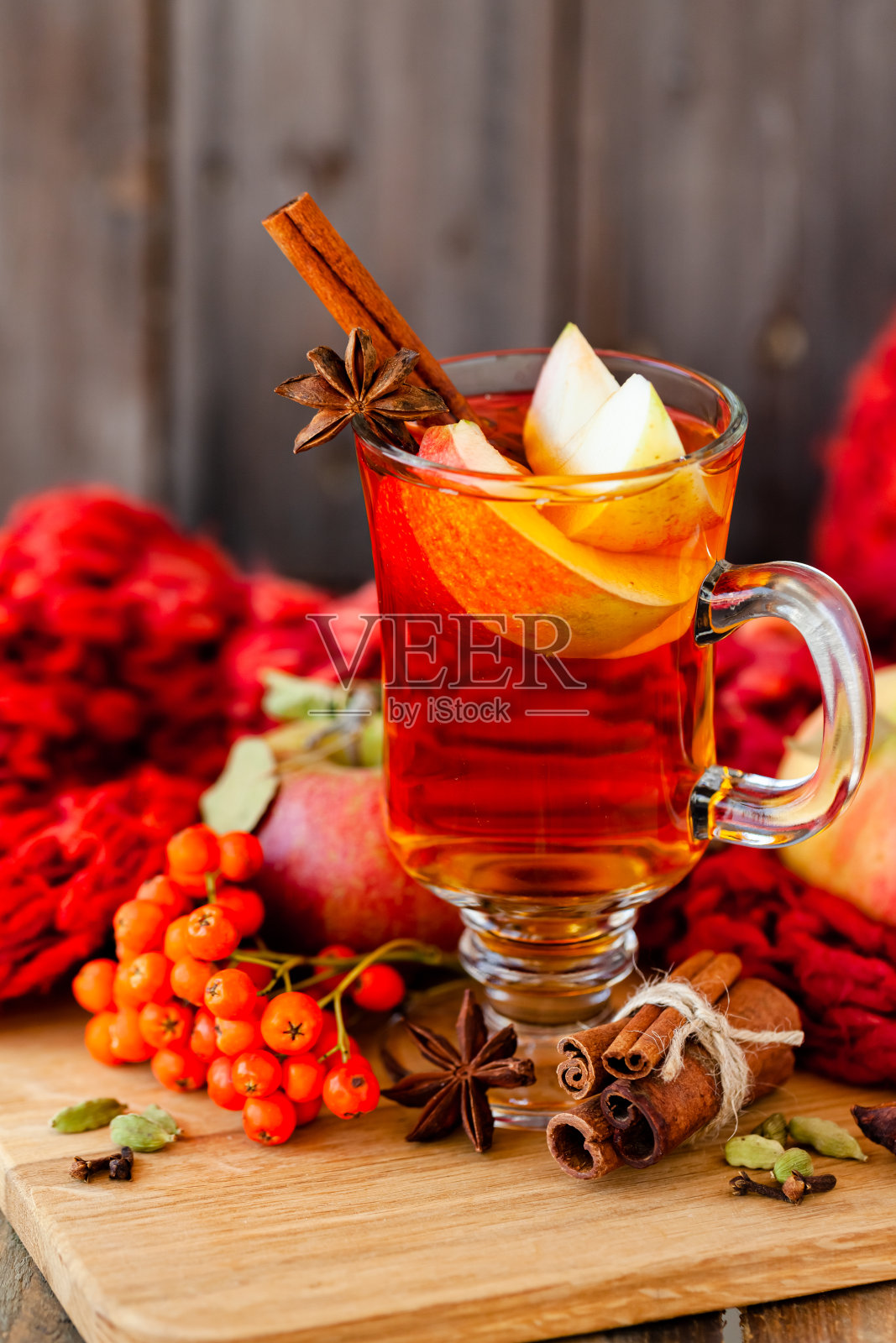 自制热水果茶，加入新鲜苹果，蜂蜜，香料:肉桂，豆蔻，茴芹，丁香。温馨的秋饮，美味的健康饮品。加香料的热葡萄酒。舒适的秋季家庭氛围。木制背景照片摄影图片