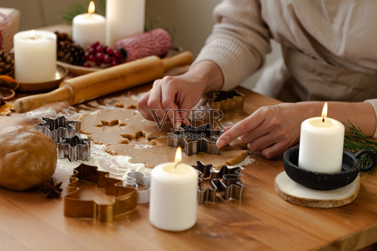 年轻的妇女在烘烤圣诞糕点，切饼干的姜饼生面团。节日的气氛中。家庭烹饪理念，烹饪过程，除夕传统。爱情的节日气氛。照片摄影图片
