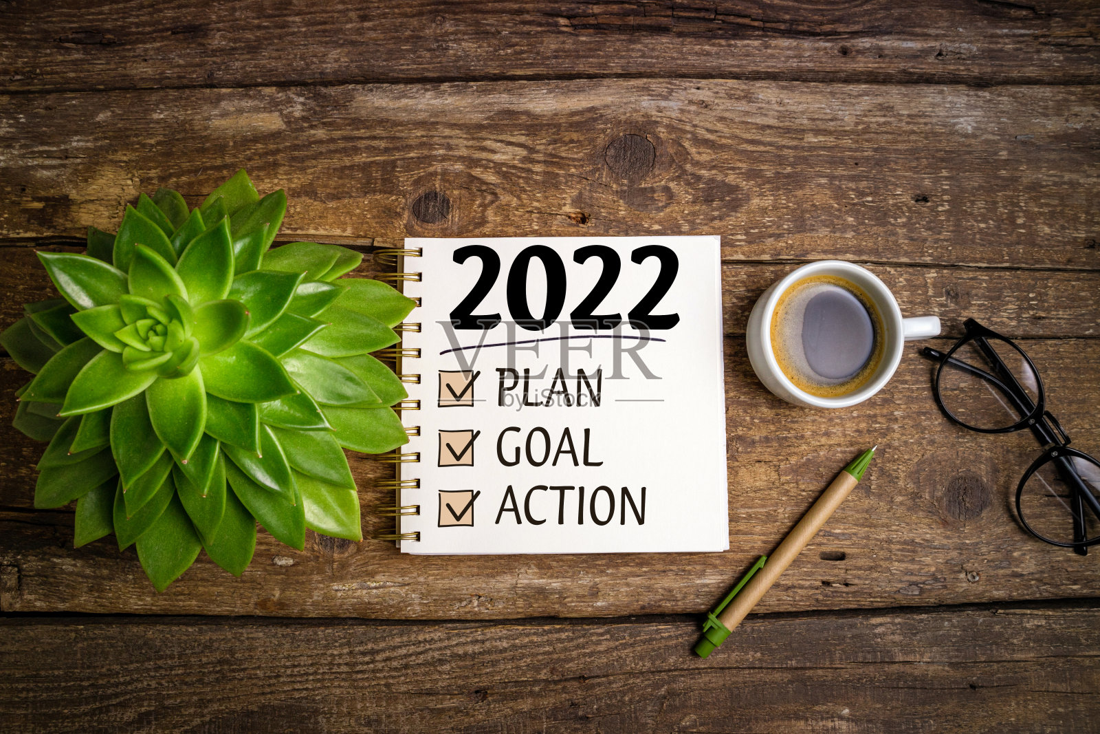 新年的目标是2022年。2022决议清单与笔记本，咖啡杯和眼镜木制背景。目标、计划、战略、经营、理念、行动理念照片摄影图片