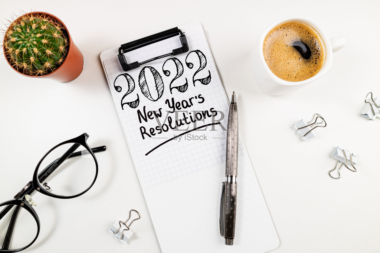 2022年新年计划已经准备就绪。2022年的目标清单，笔记本，咖啡杯和眼镜在白色的桌子上。目标、计划、策略、决议、业务照片摄影图片