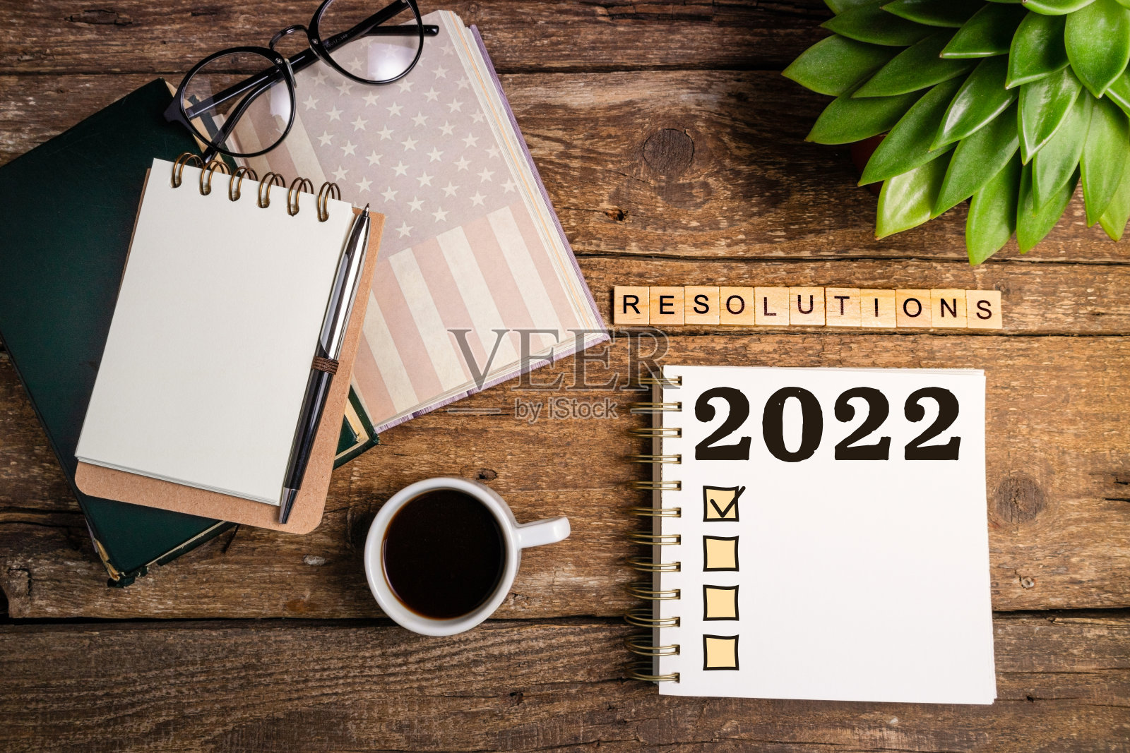 2022年新年决心清单。办公桌上有笔记本、咖啡杯、植物多肉。目标，计划，想法，事业，动机，健康观念照片摄影图片