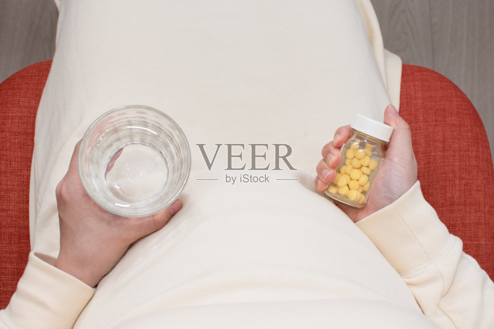 一位年轻的亚洲孕妇正在服药照片摄影图片