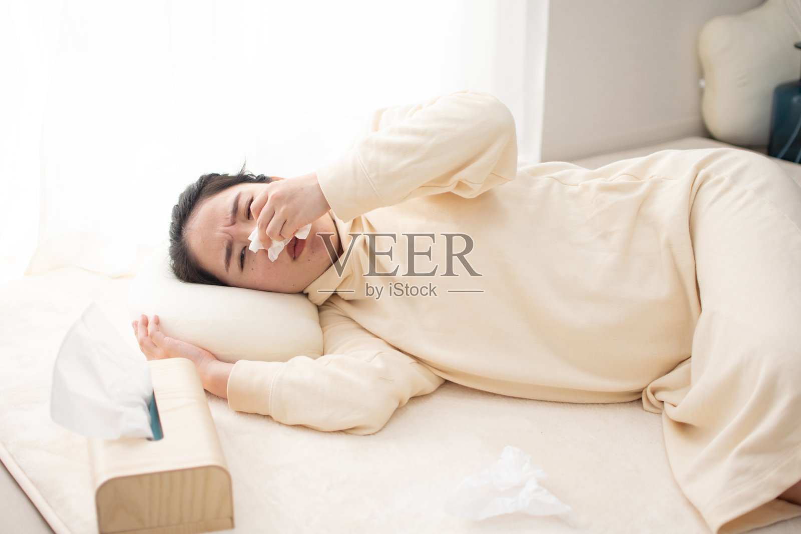 一个年轻的亚洲孕妇生病了，躺在地板上照片摄影图片