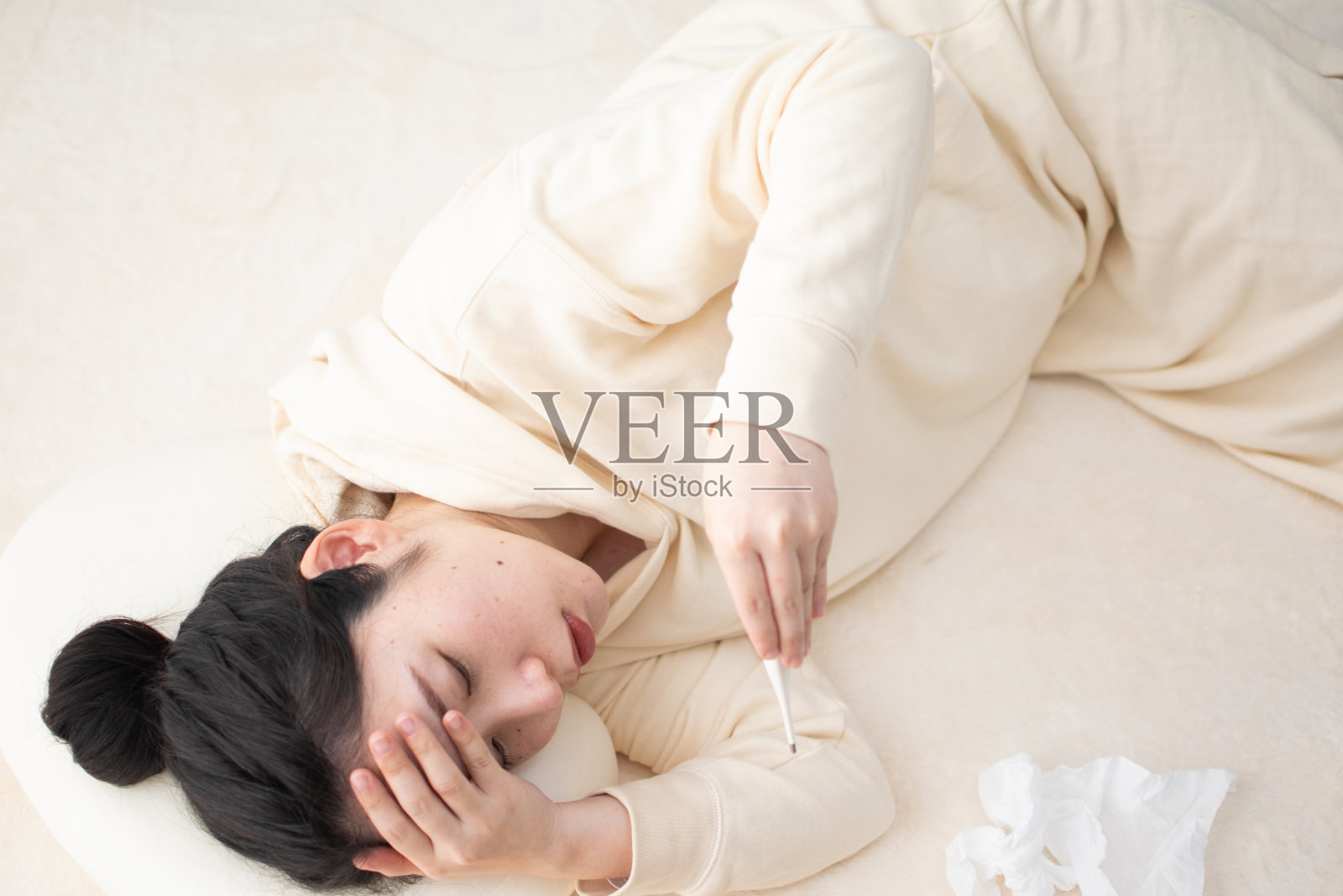 一个年轻的亚洲孕妇躺着检查体温计照片摄影图片