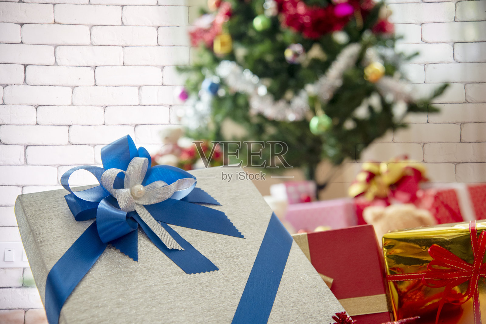 圣诞礼物礼品盒在小圣诞树下装饰节日冬季圣诞节快乐新年庆祝。在舒适的客厅里为家庭装饰赠送礼品盒。圣诞快乐，新年快乐照片摄影图片