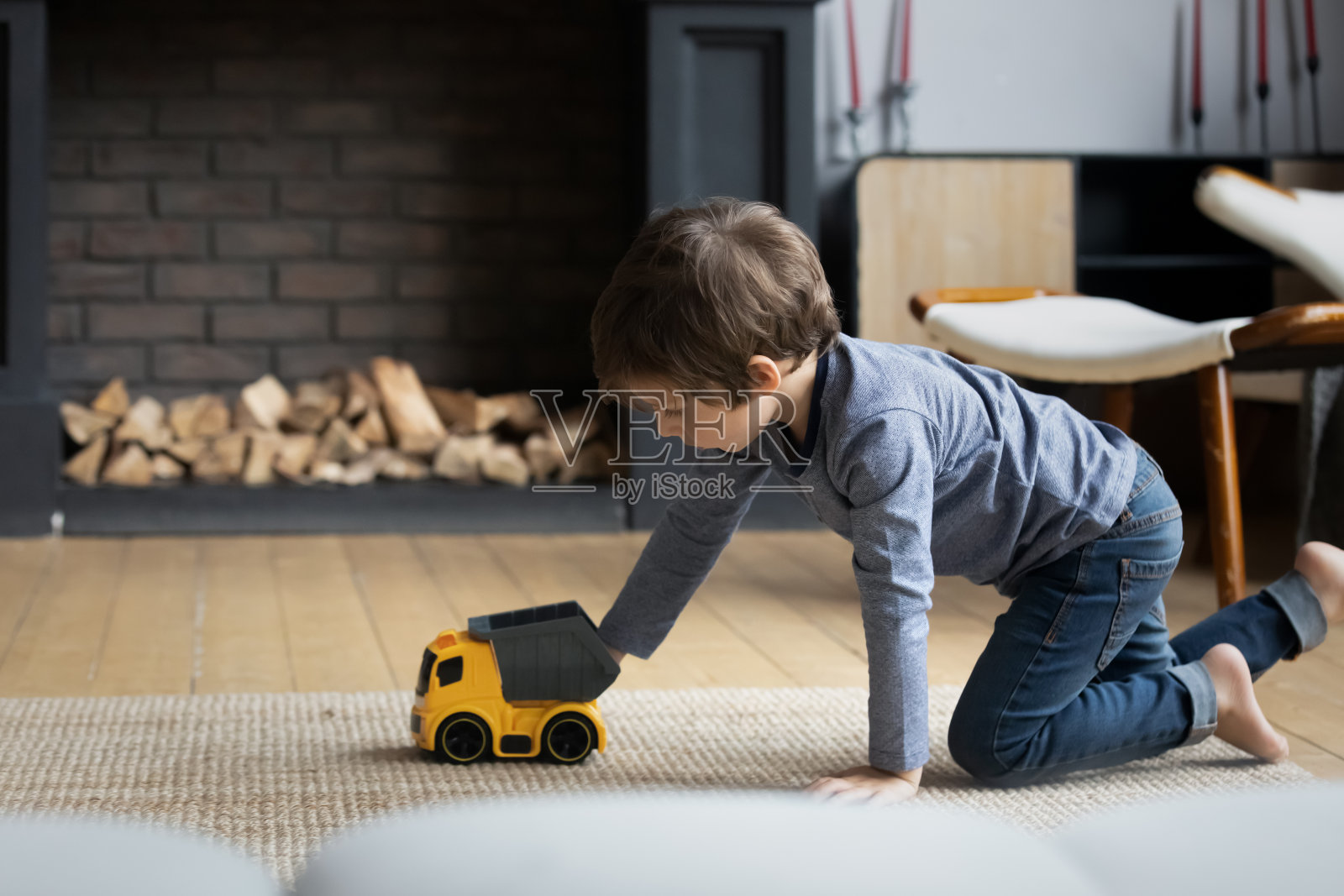 专注男孩玩玩具在暖气地板在家里照片摄影图片