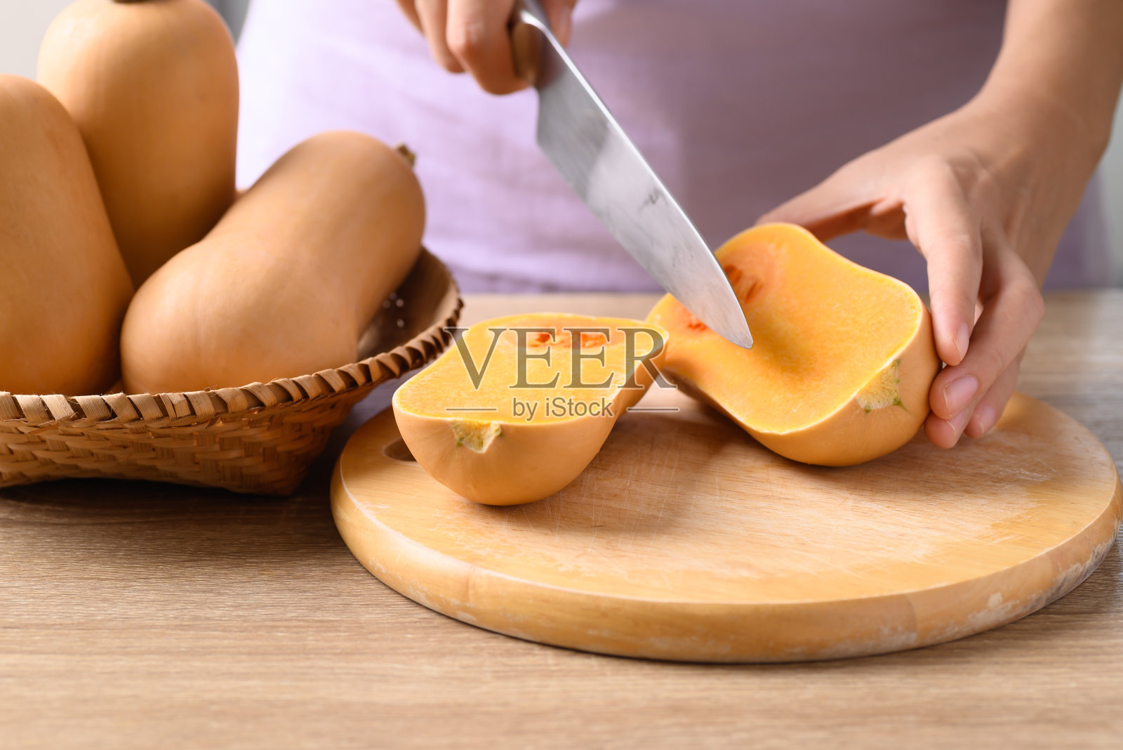 女人手握菜刀，正在切冬南瓜照片摄影图片