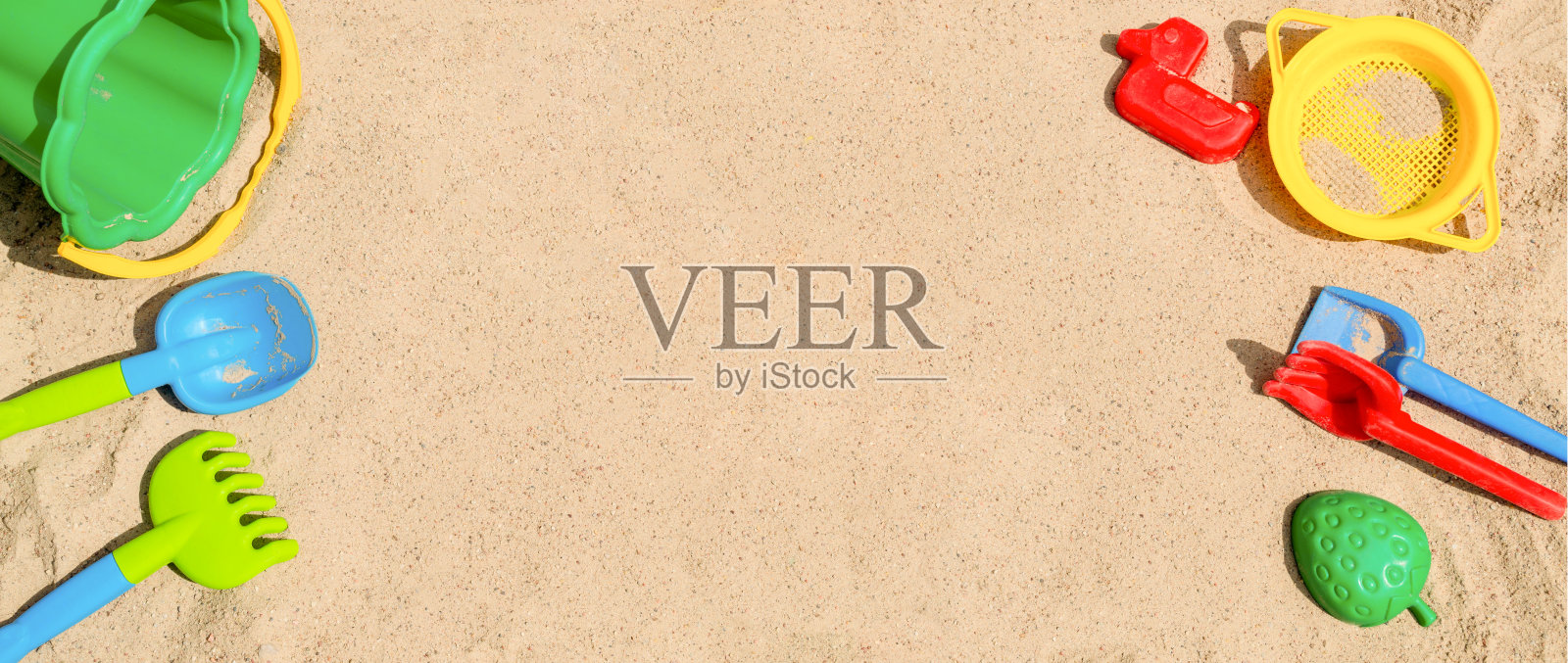 沙箱。背景与明亮的彩色铲，耙，模具和桶照片摄影图片