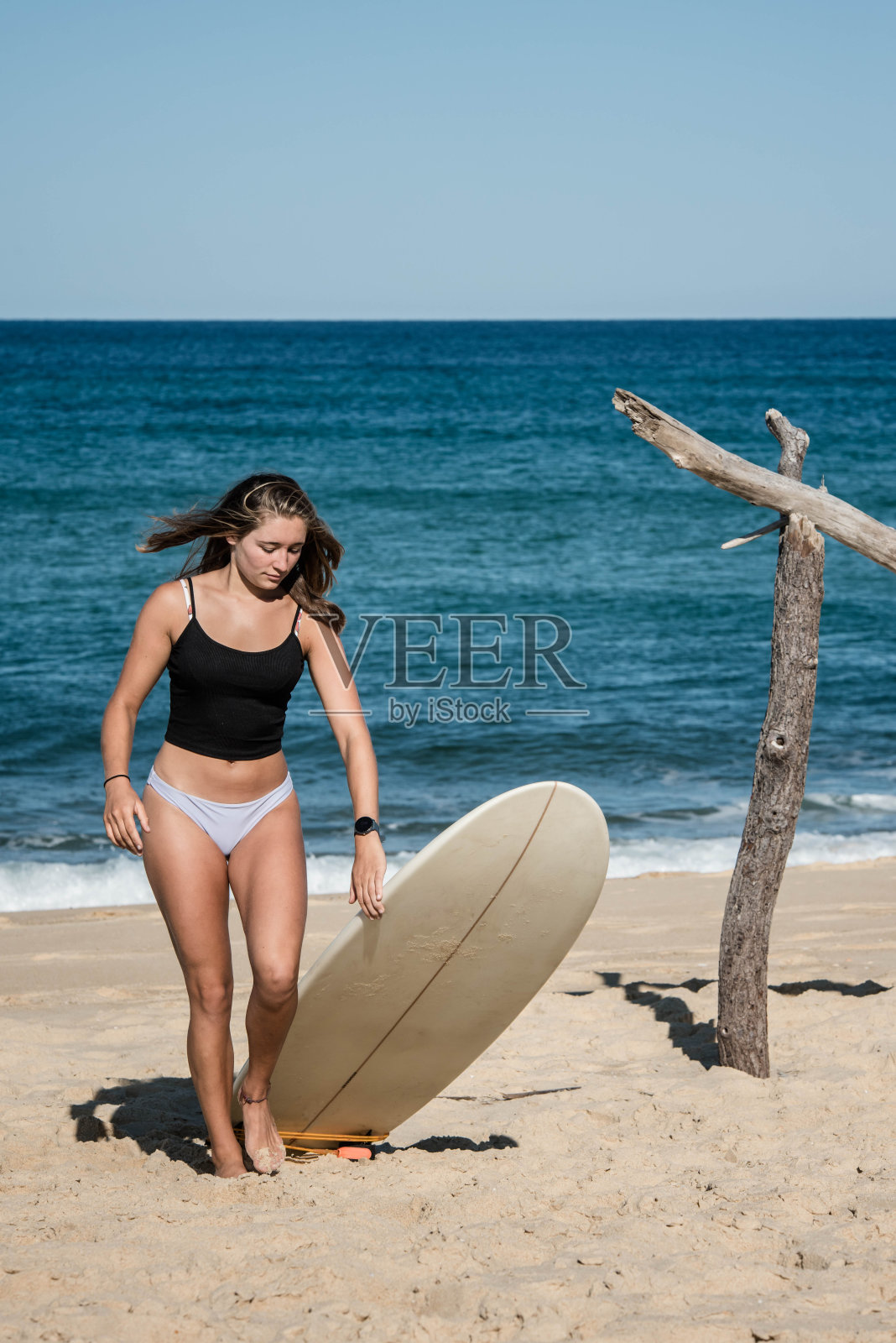 漂亮的年轻女人在阳光明媚的海滩上冲浪照片摄影图片