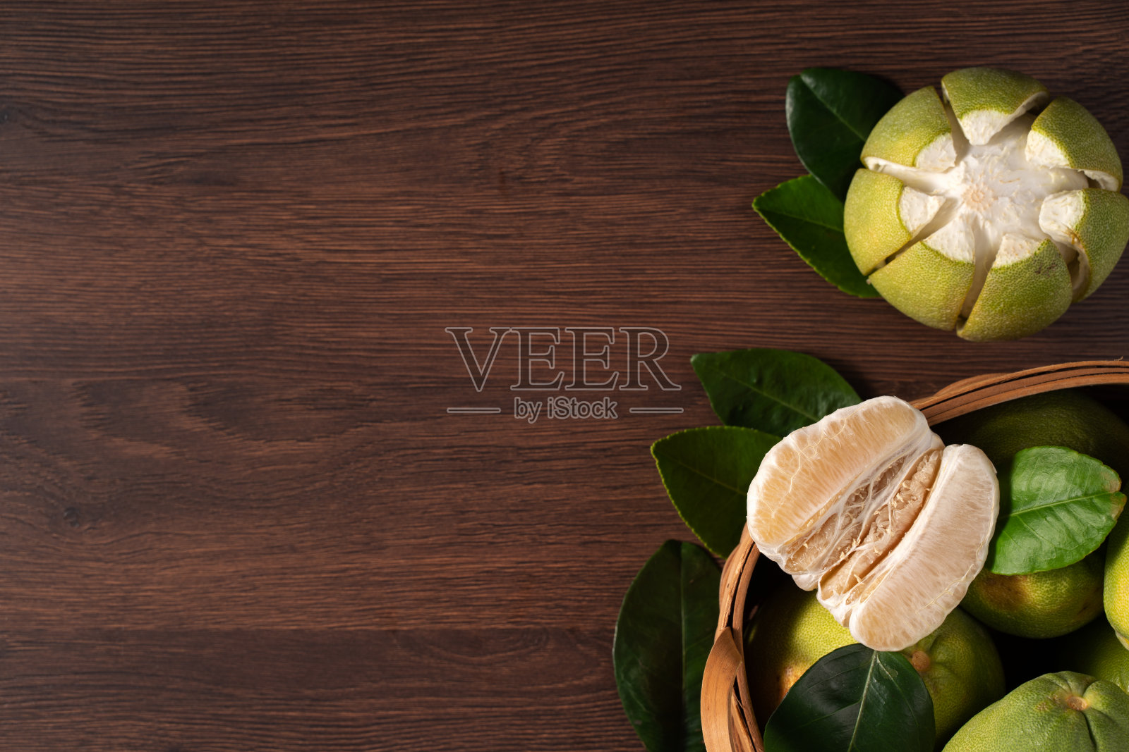 新鲜的柚子水果放在深色木桌背景上。照片摄影图片