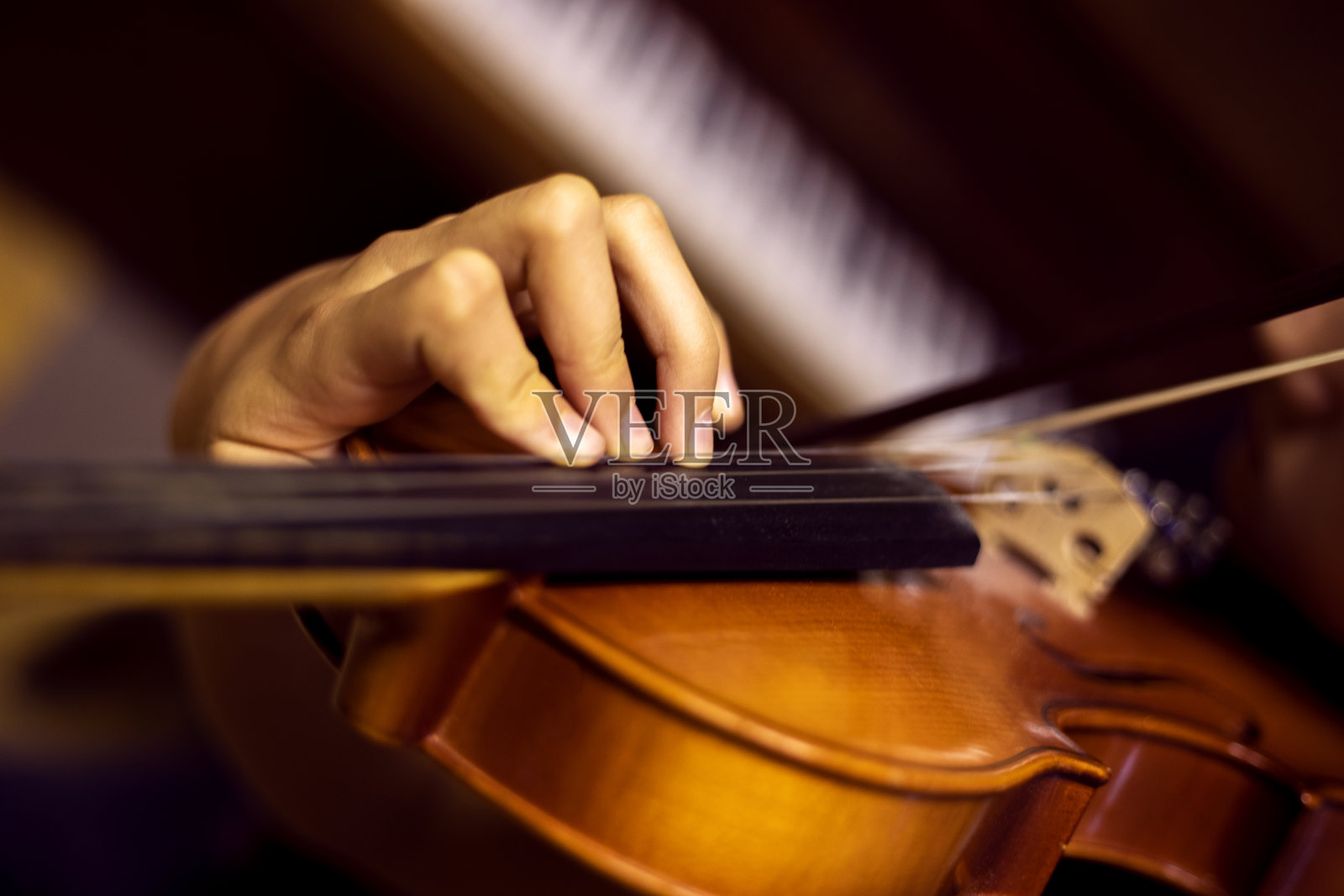 年轻小提琴手的左手水平按压琴颈上的弦照片摄影图片