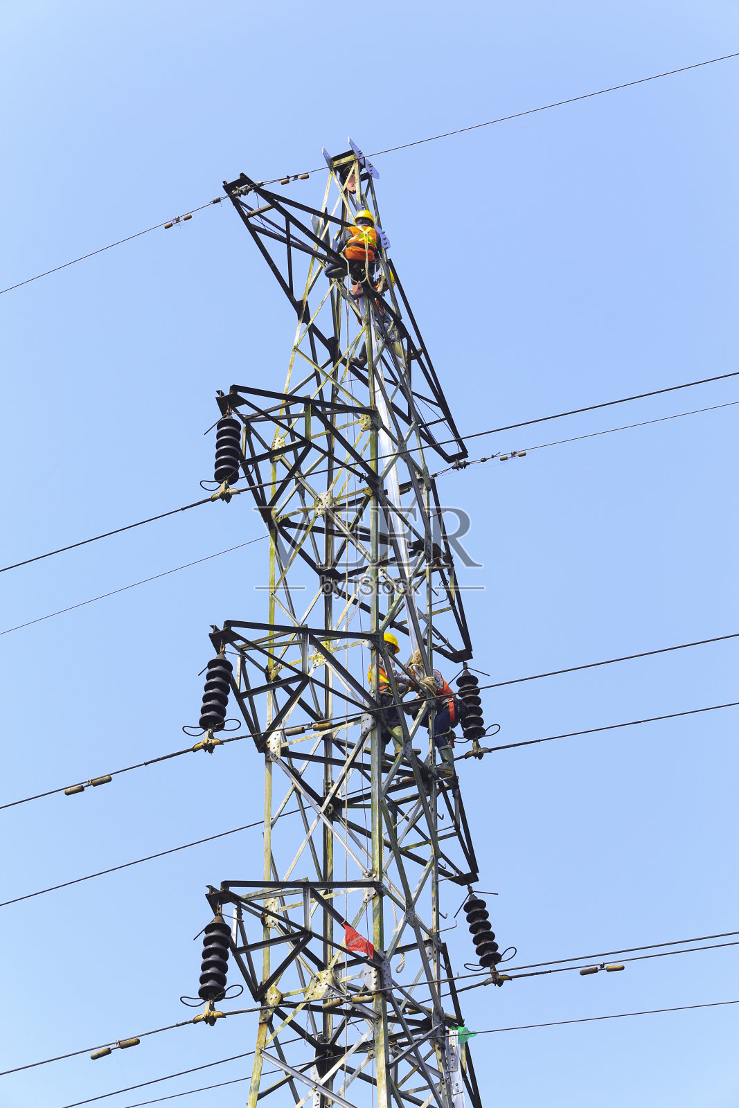 电工修理电线杆上的电线。这个电塔高出地面40 - 5米。照片摄影图片