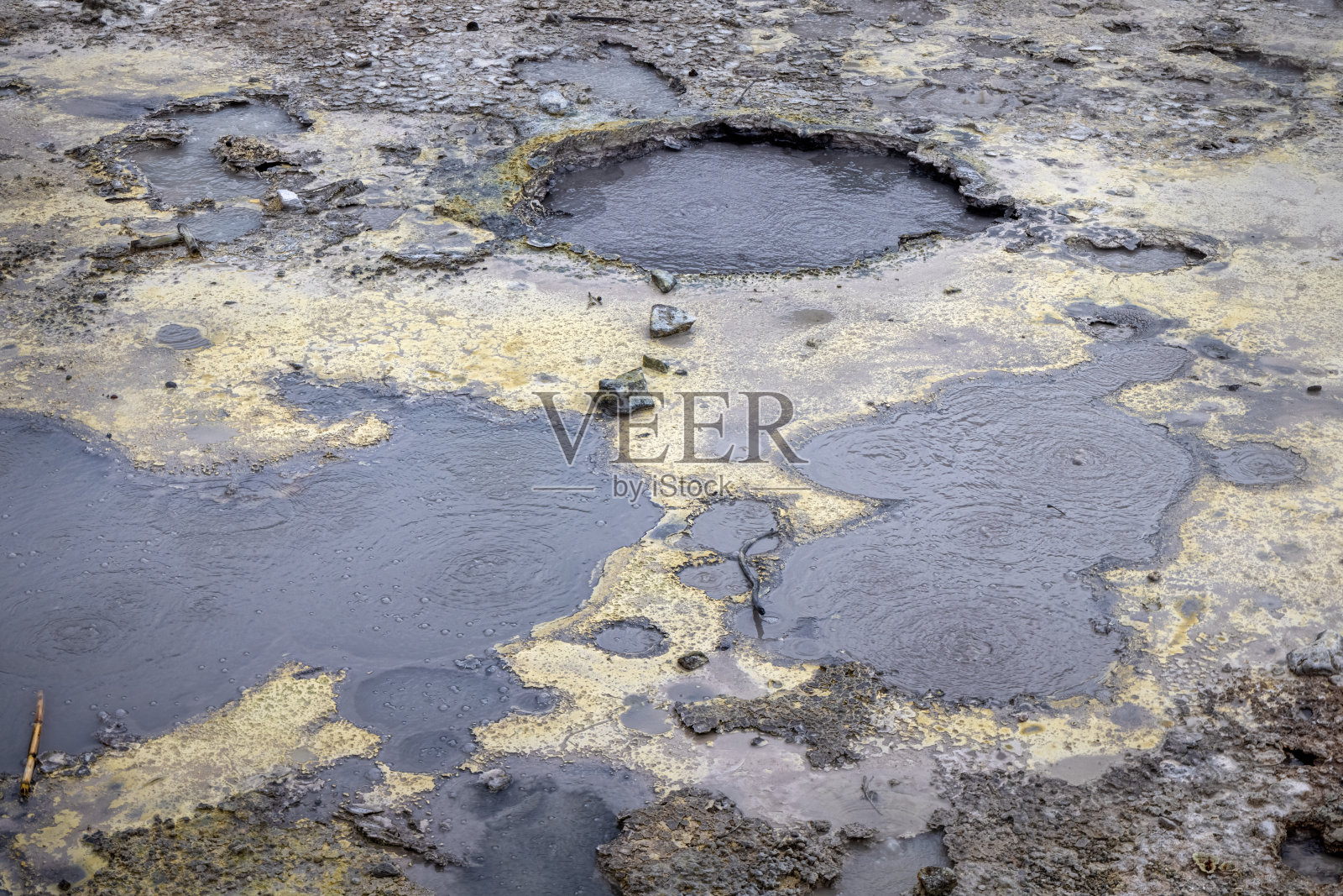 地上有个洞，里面有沸腾的硫磺水照片摄影图片