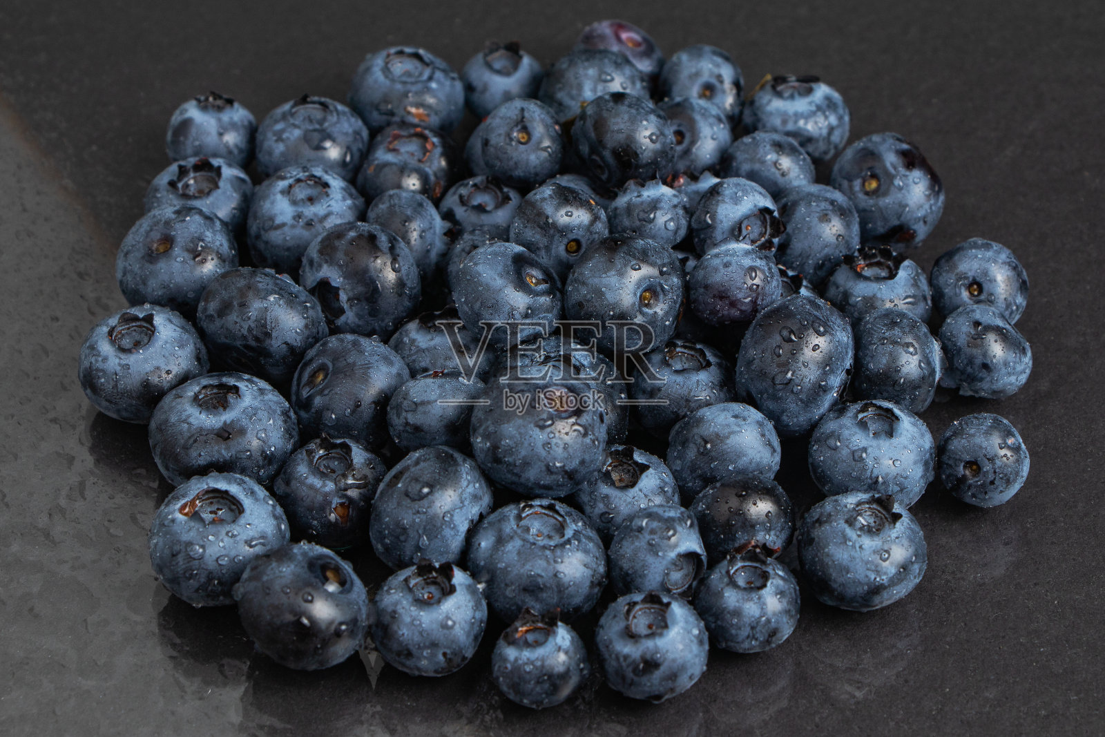 蓝莓水果背景。水珠滴在成熟甜美的蓝莓上。收集蓝色和黑色的浆果。概念上的食物图片. .照片摄影图片