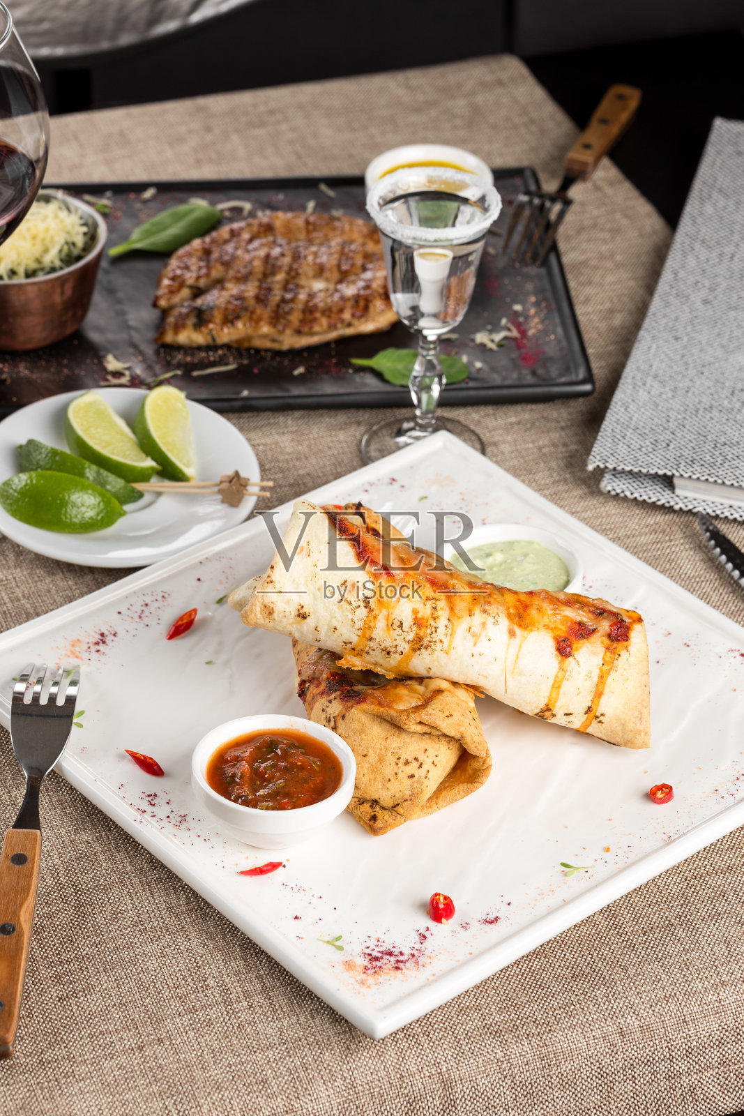 墨西哥餐厅快餐卷肉卷肉，酱汁和龙舌兰酒在餐厅的桌子上照片摄影图片