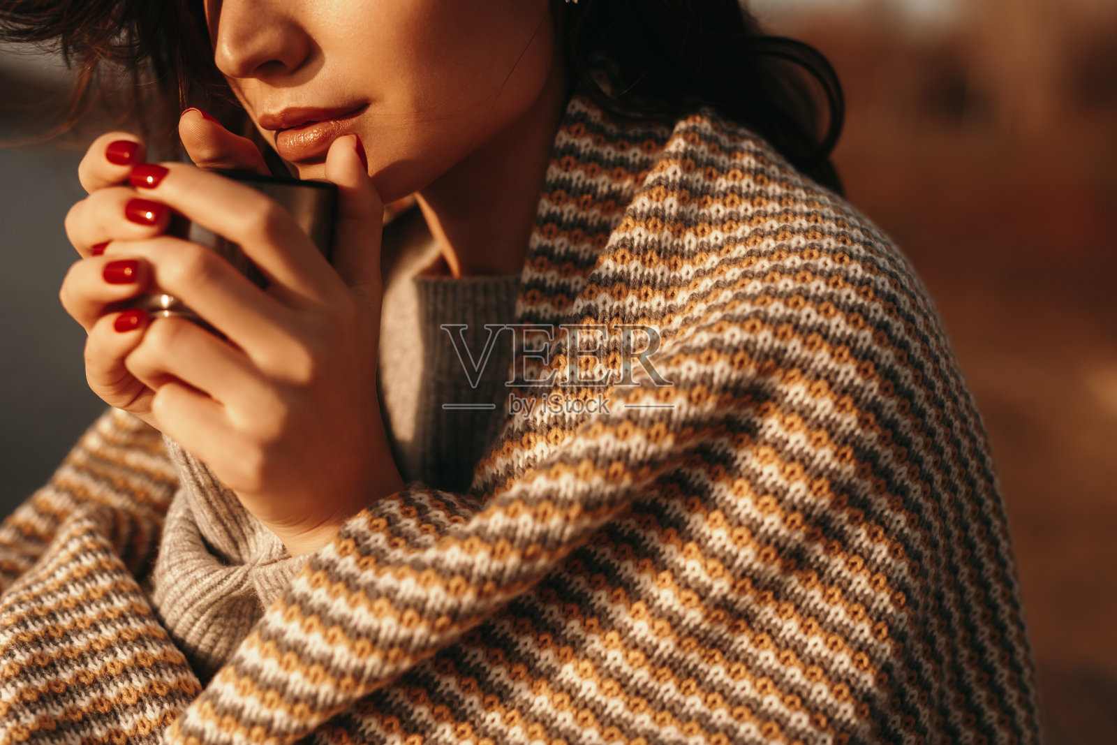 穿着针织品的女人在秋天的大自然中喝咖啡照片摄影图片