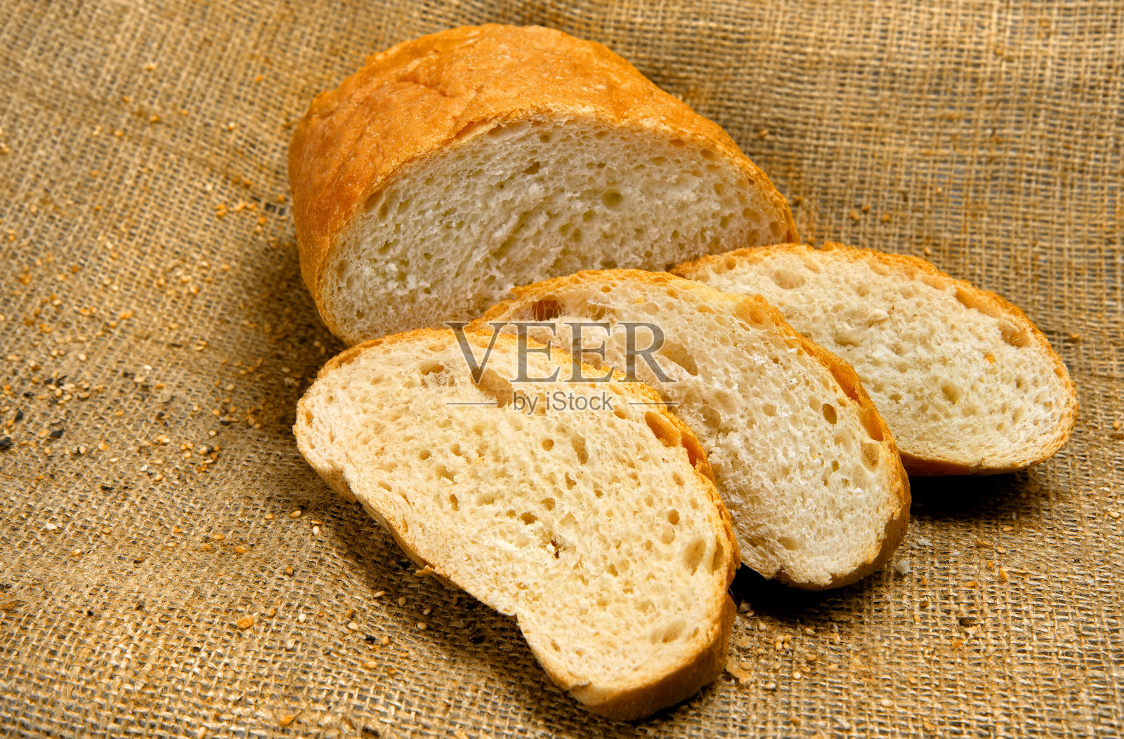 面包，切成薄片，以织物为背景。照片摄影图片