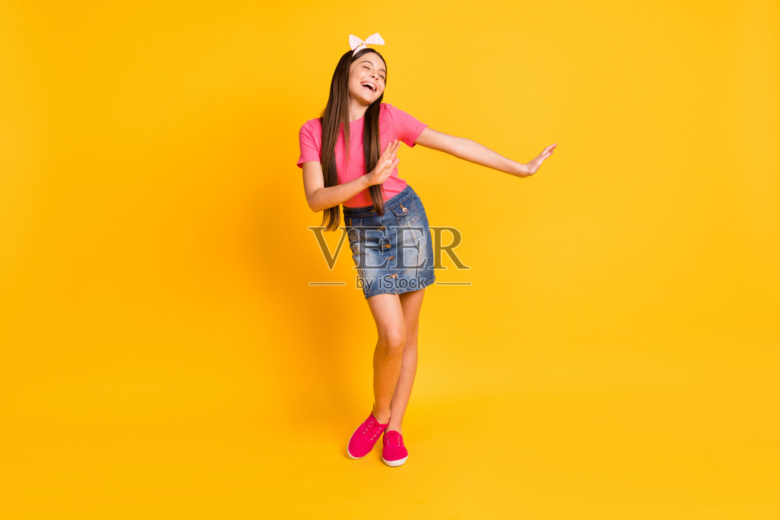 有趣迷人的女学生穿着粉红色t恤微笑跳舞孤立的黄色背景照片照片摄影图片