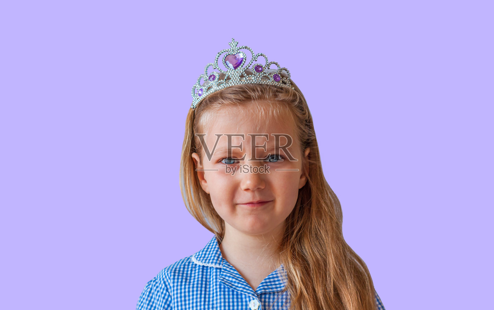 美丽的小公主戴着闪闪发光的银色王冠。感情用事的年轻女士长波浪头发在蓝色裙子肖像照片摄影图片