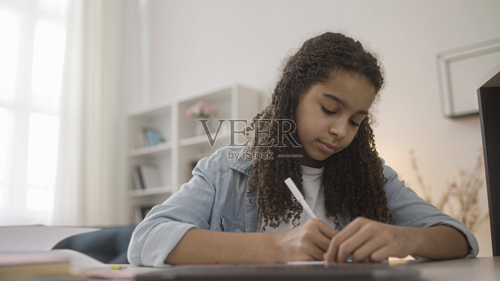 十几岁的女孩在笔记本上做作业，做笔记，远程学习照片摄影图片