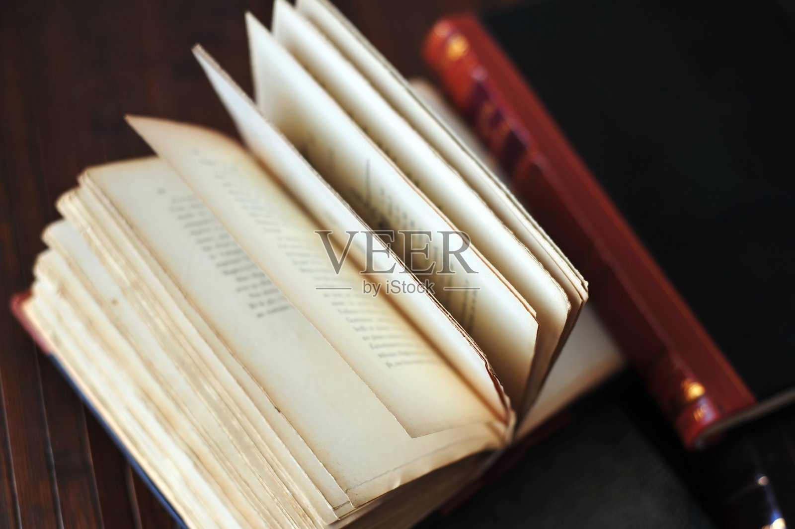 打开木制背景上破旧的书照片摄影图片