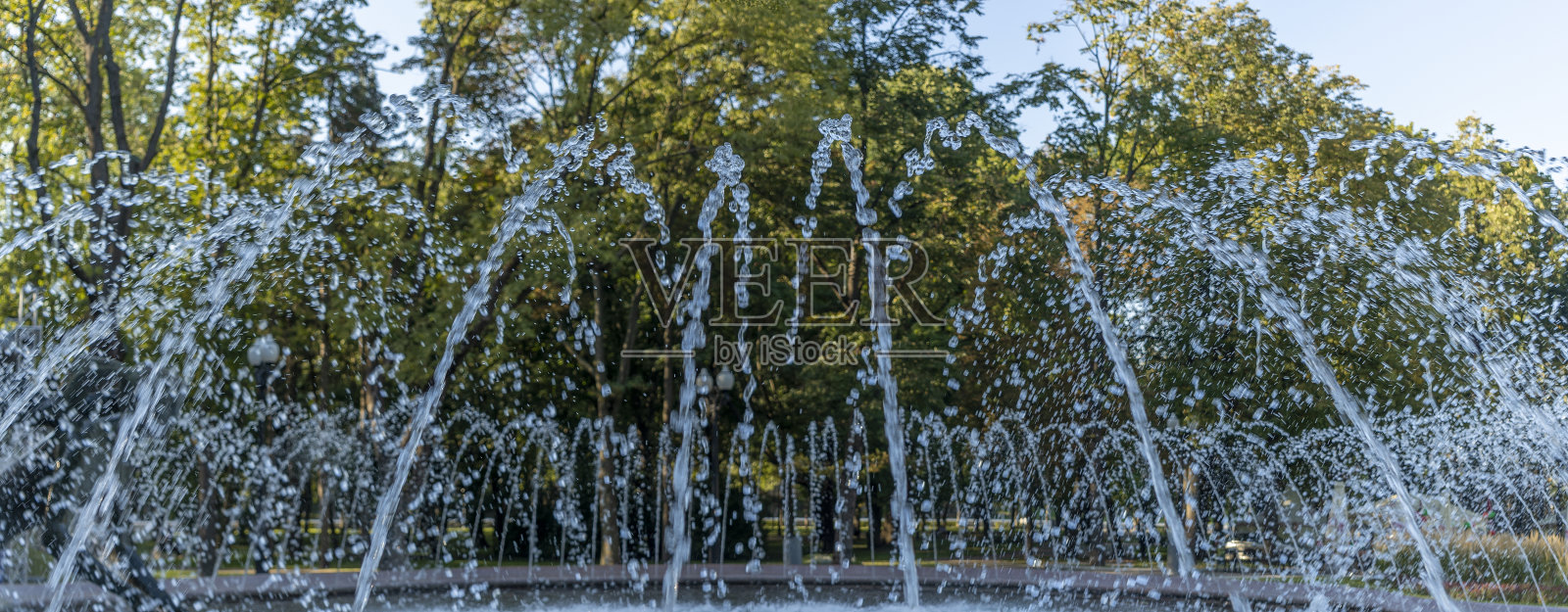 在夏日城市公共城市公园的喷泉里泼水。水喷射抽象图像特写。照片摄影图片