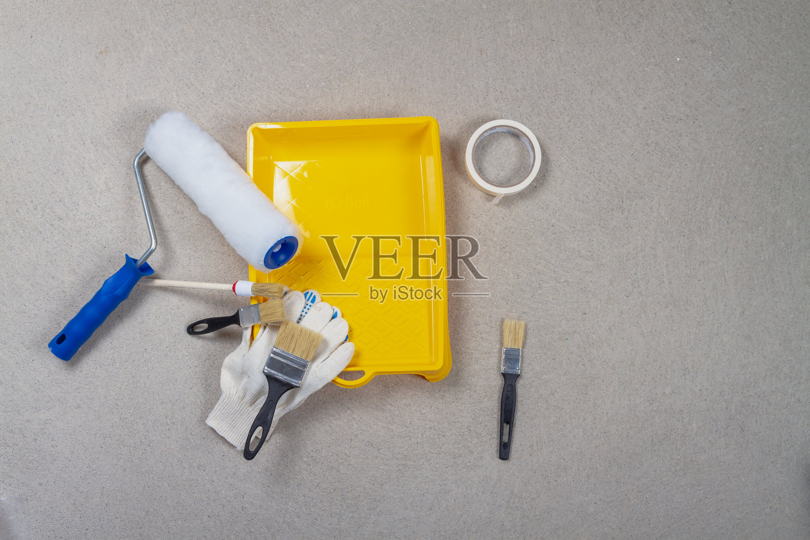 粉刷墙壁的工具。工作前准备好黄色漆盘、漆辊、刷子、手套、漆带照片摄影图片