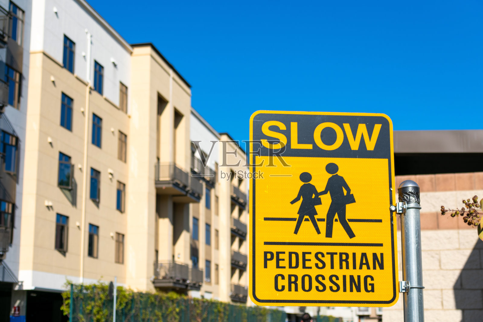 慢行人行横道路标。位于城市住宅区的现代中高层公寓综合体。照片摄影图片