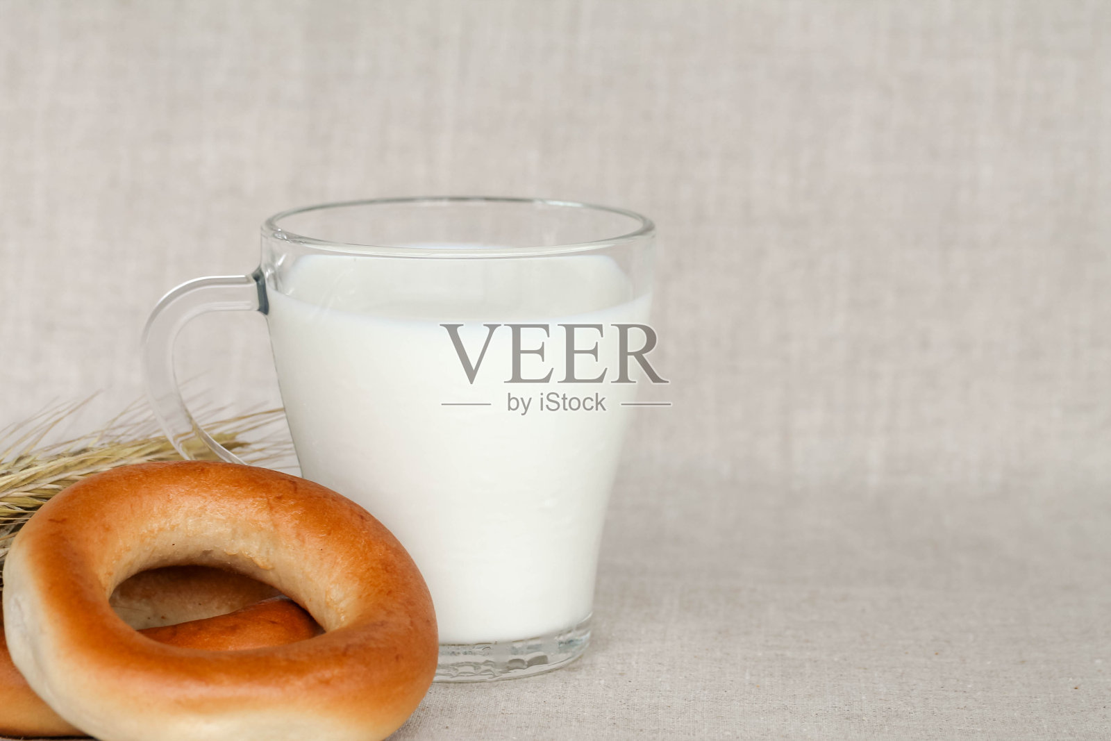 百吉饼和一杯用粗麻布铺的牛奶照片摄影图片