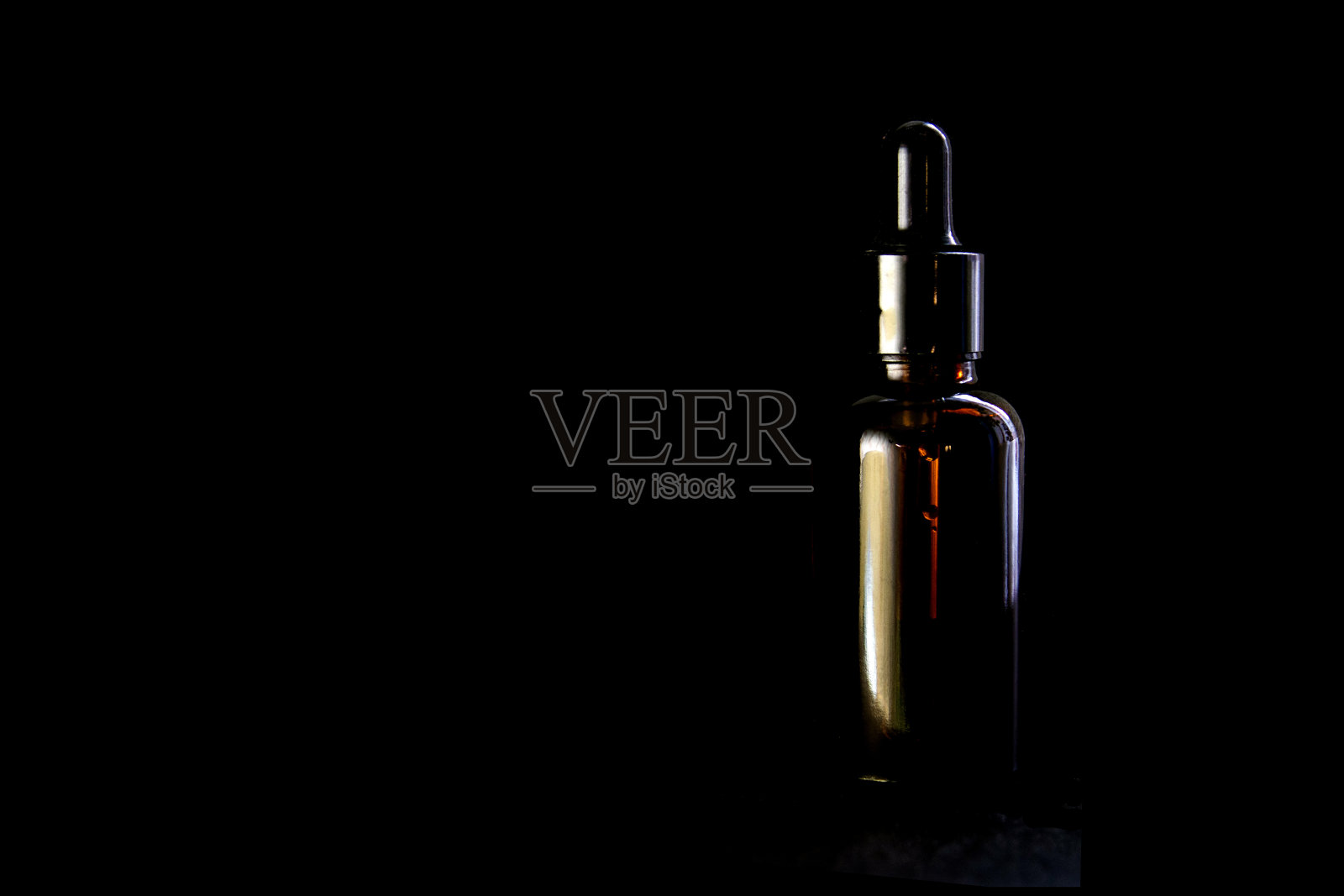 滴瓶化妆品隔离在黑色背景。包装设计。创意的展示方式，带有复制空间的正面视图。化妆品的模型照片摄影图片