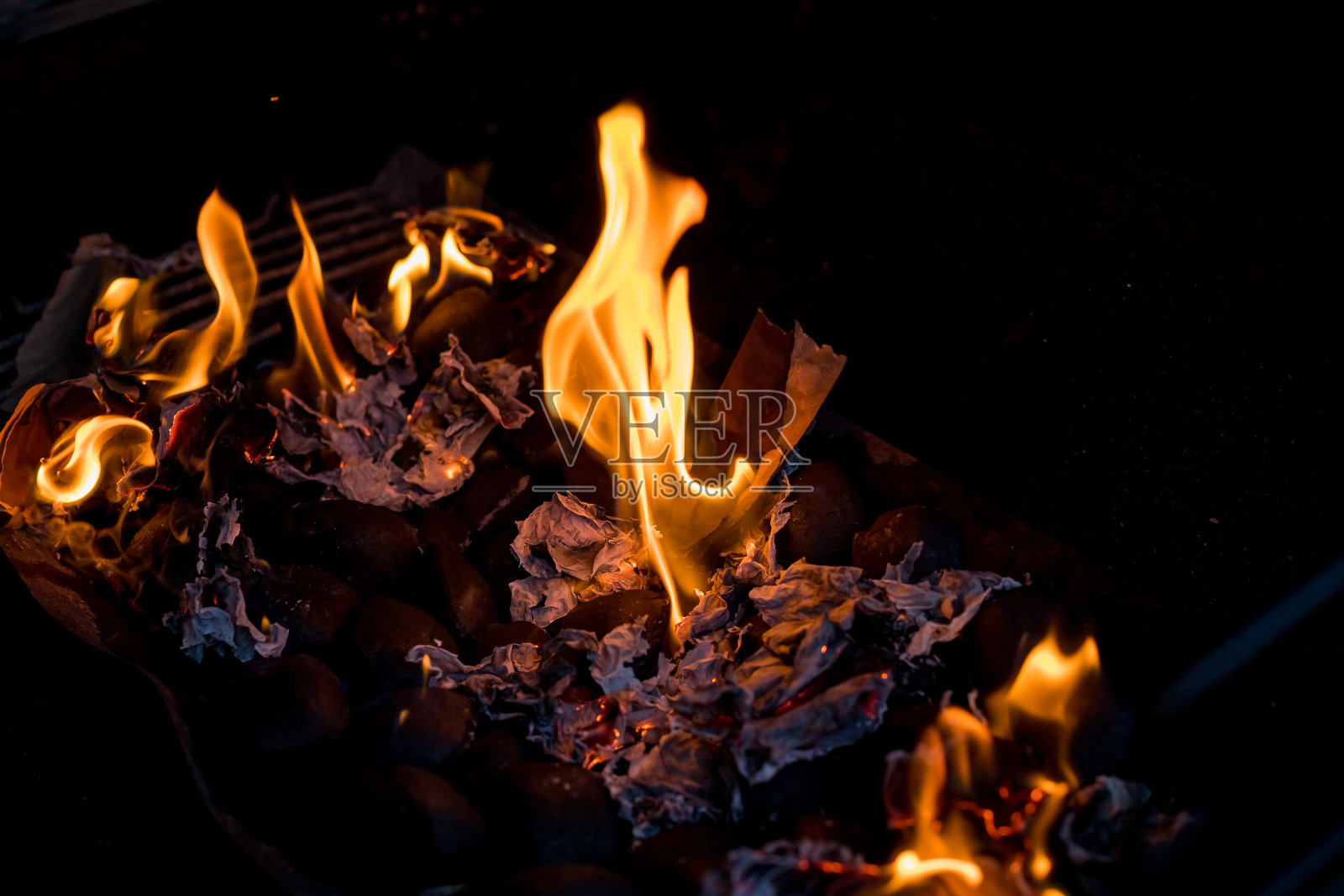 烧烤黑色背景上的火烧烤。燃烧的木炭。焦点是火中的热炭。燃烧木炭背景与火和火花。煤在室外闷烧照片摄影图片