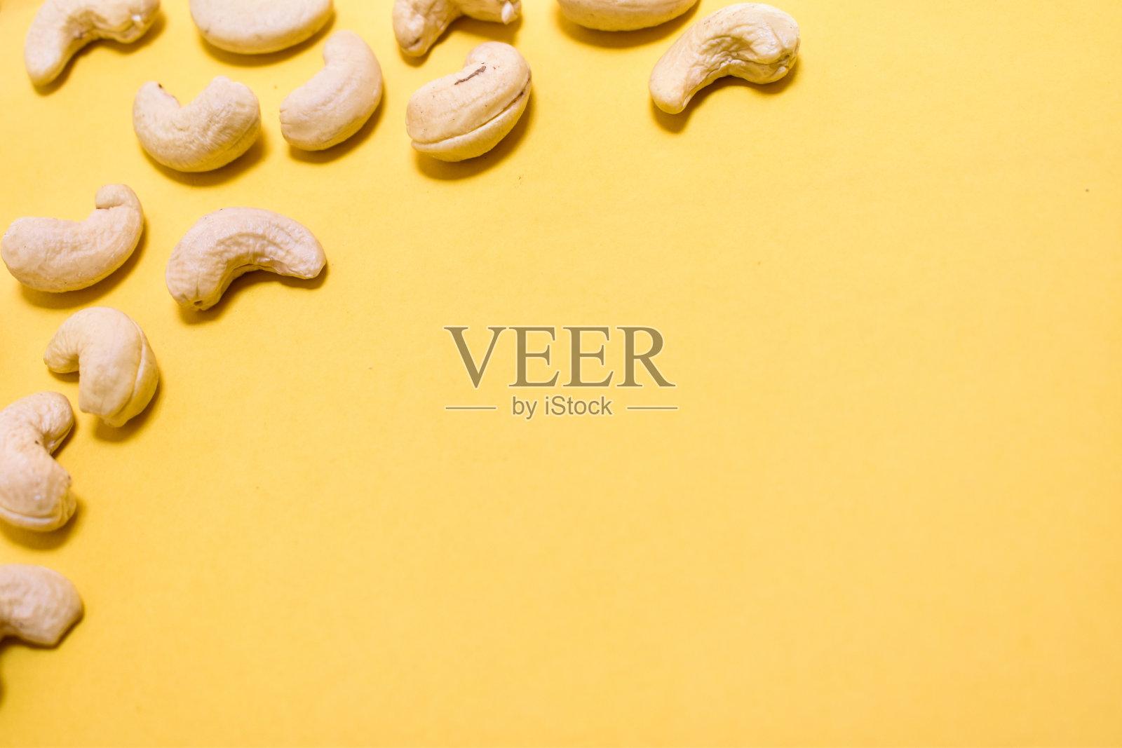 腰果与黄色背景与文字的空间照片摄影图片