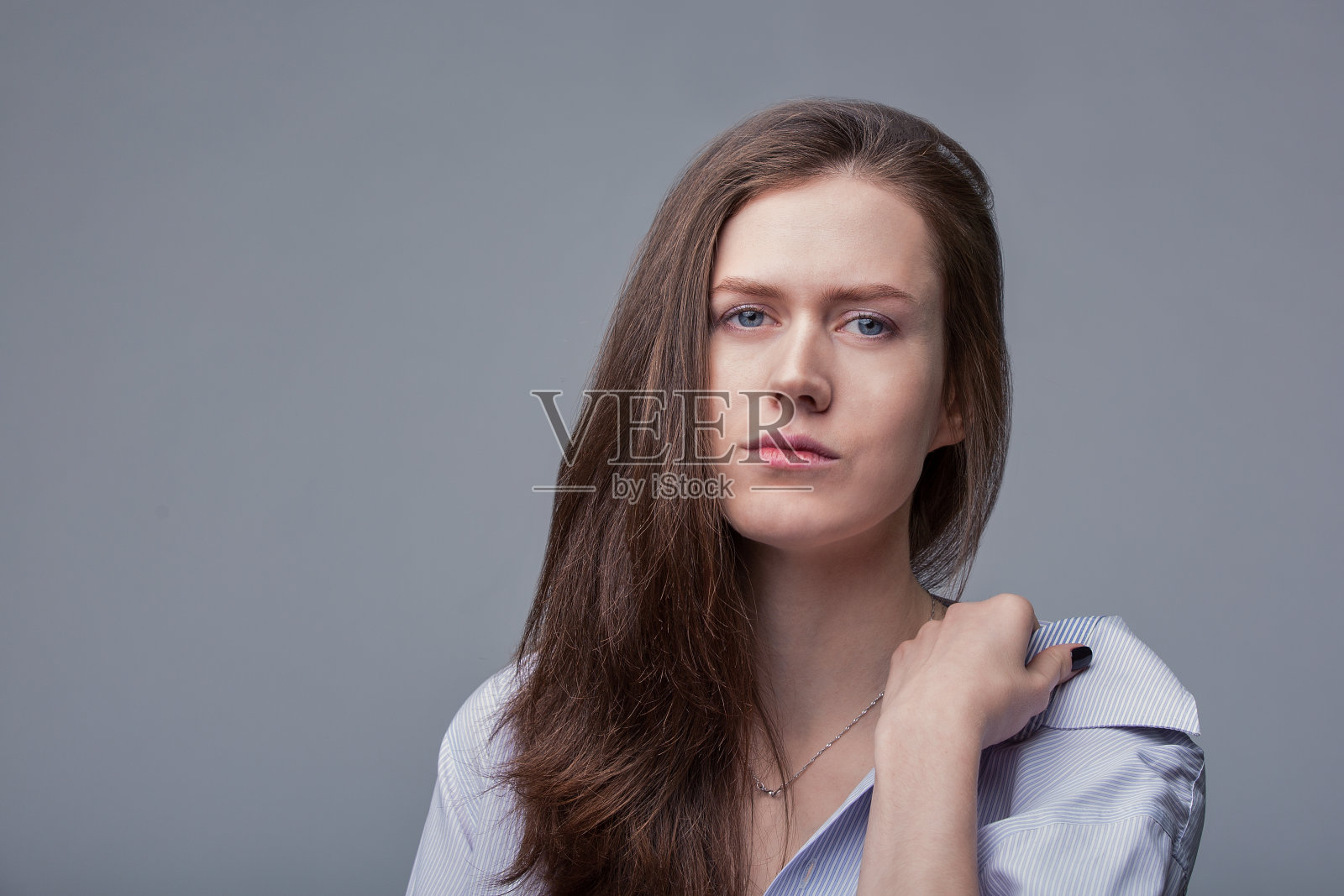 蓝色眼睛的美丽女孩在灰色背景上摆姿势照片摄影图片