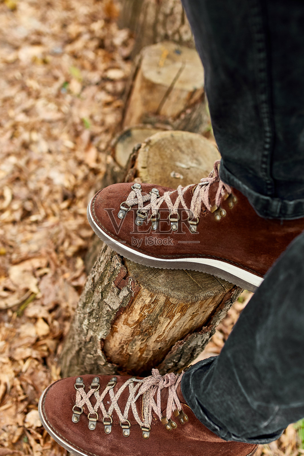 俯视图人站在秋天树叶和木头背景徒步登山靴照片摄影图片