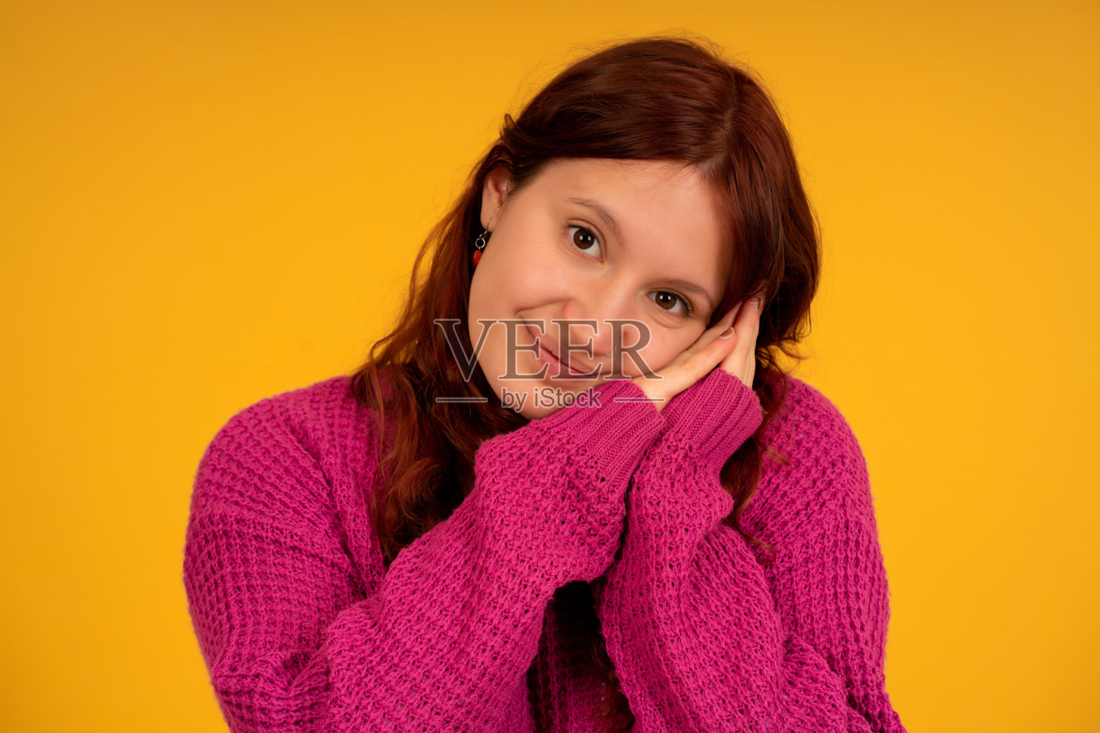 年轻疲惫的女人摆姿势，双手放在脸上。照片摄影图片