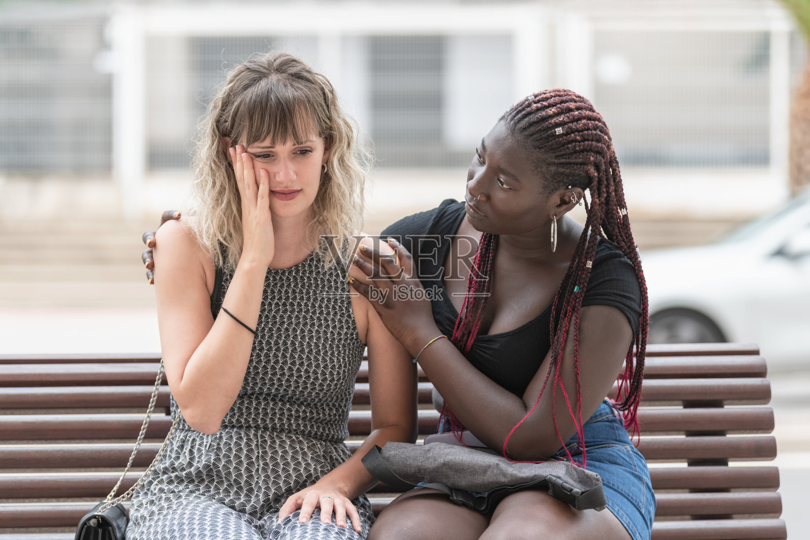 当她的朋友安慰她的时候，一名成年女性带着担忧的表情照片摄影图片