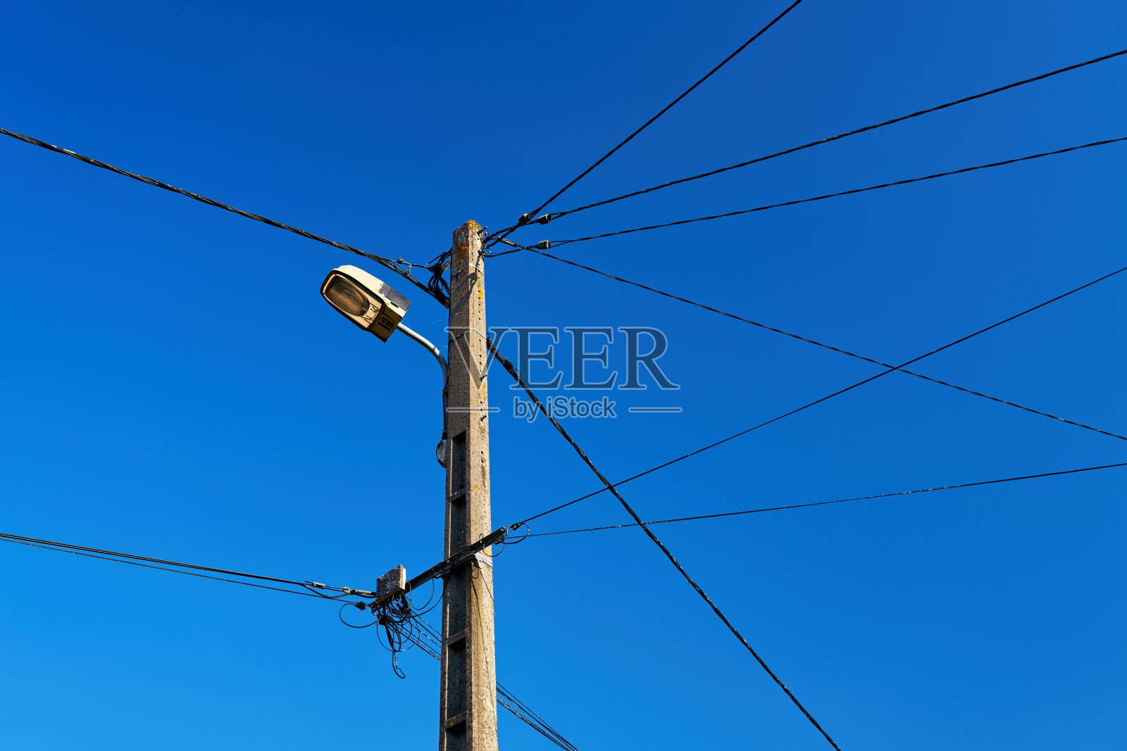 电线布线怪异的电线杆和蓝天下的街灯照片摄影图片