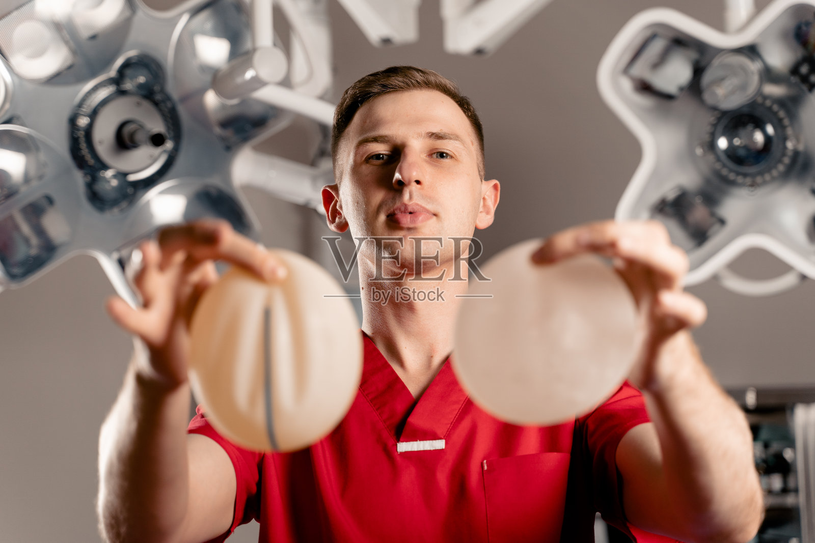 外科医生展示了不同类型的硅胶植入物。隆胸手术。照片摄影图片
