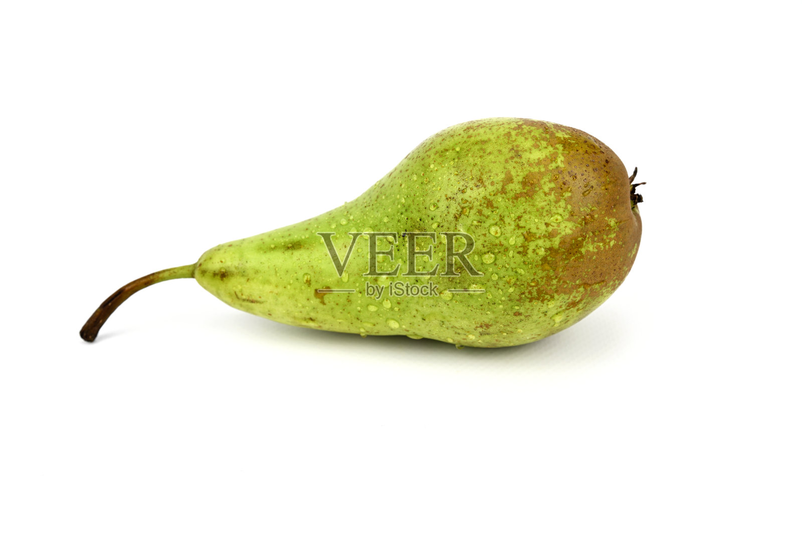 那只绿色的梨侧身躺着。一根干茎伸出来。照片摄影图片