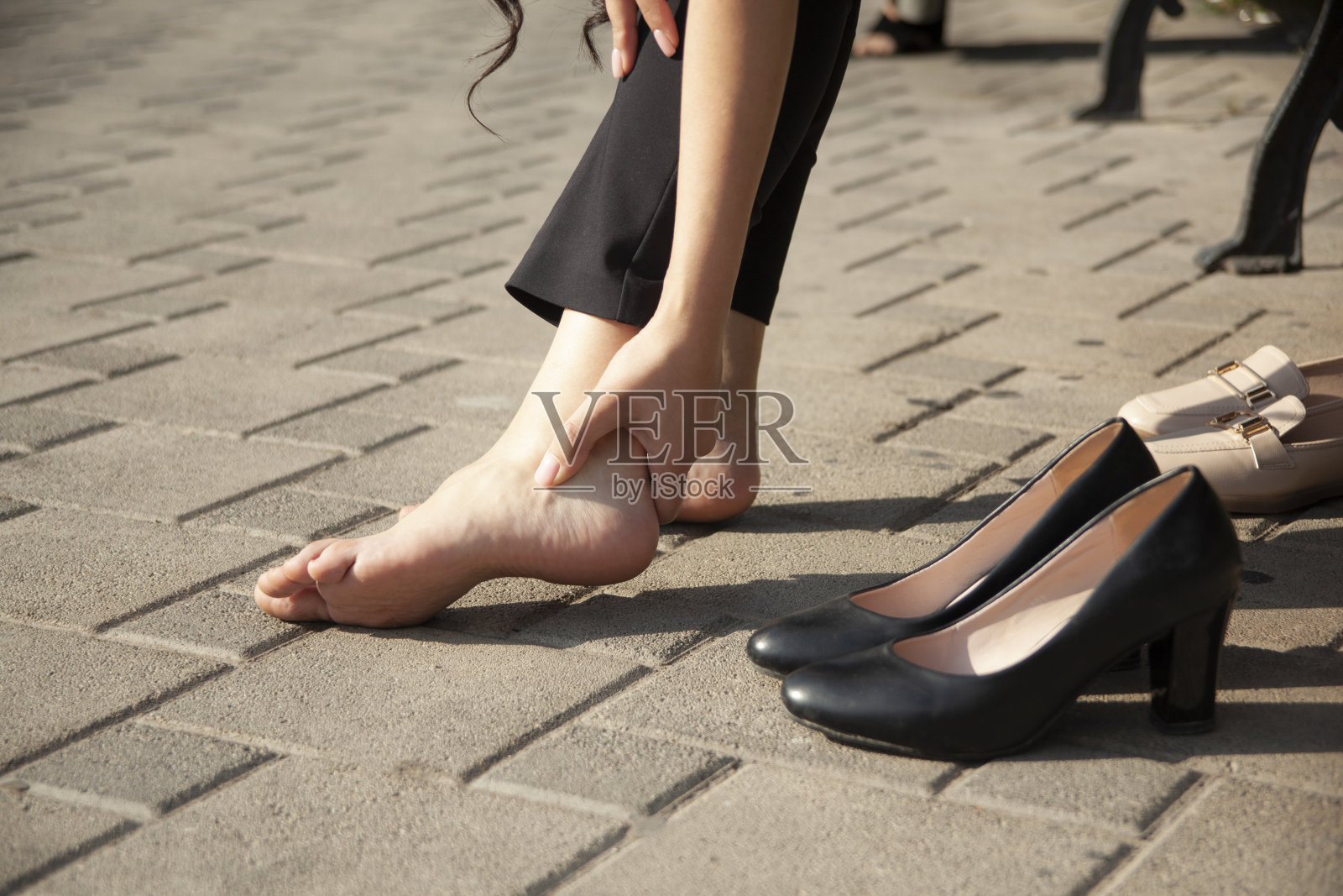 女人在街上脱掉高跟鞋照片摄影图片